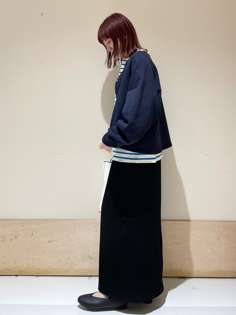 ブルー系のニット/セーター、ブルー系のTシャツ/カットソー、ブラック系のパンプスを着用したレディースの春コーディネートの4枚目の写真