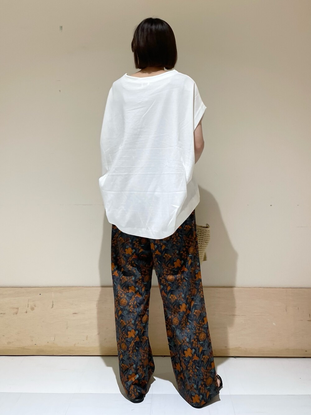 オレンジ系のその他パンツ、ホワイト系のTシャツ/カットソー、ベージュ系のトートバッグを着用したレディースの夏コーディネートの5枚目の写真