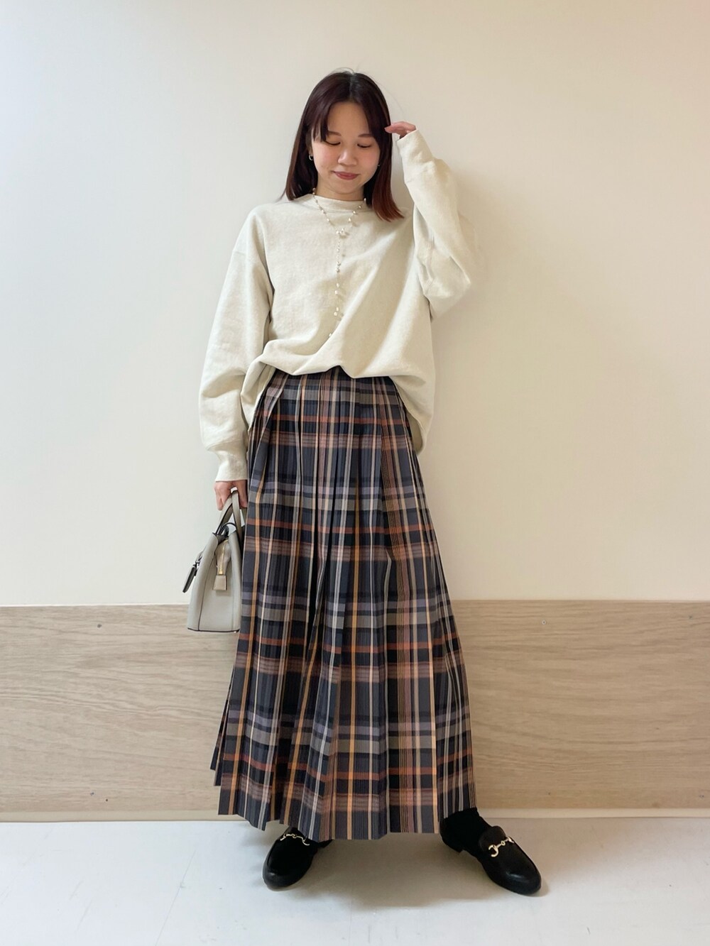 ホワイト系のスウェット、グレー系のスカートを着用したレディースの冬コーディネートの2枚目の写真