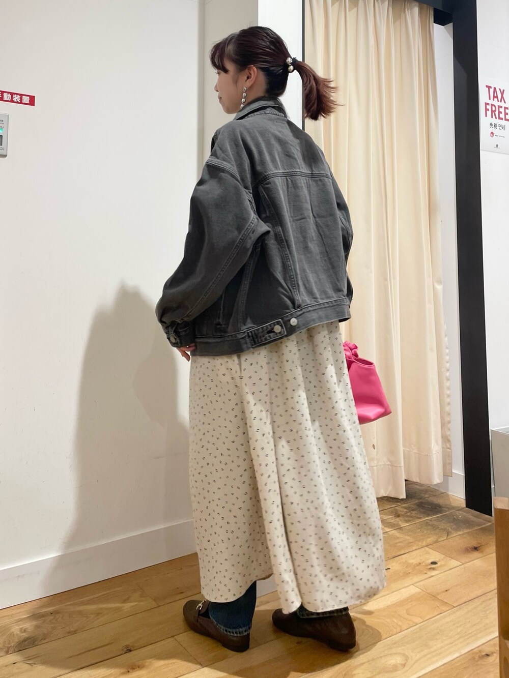 ブラック系のデニムジャケット、ブルー系のデニムパンツを着用したレディースの春コーディネートの4枚目の写真