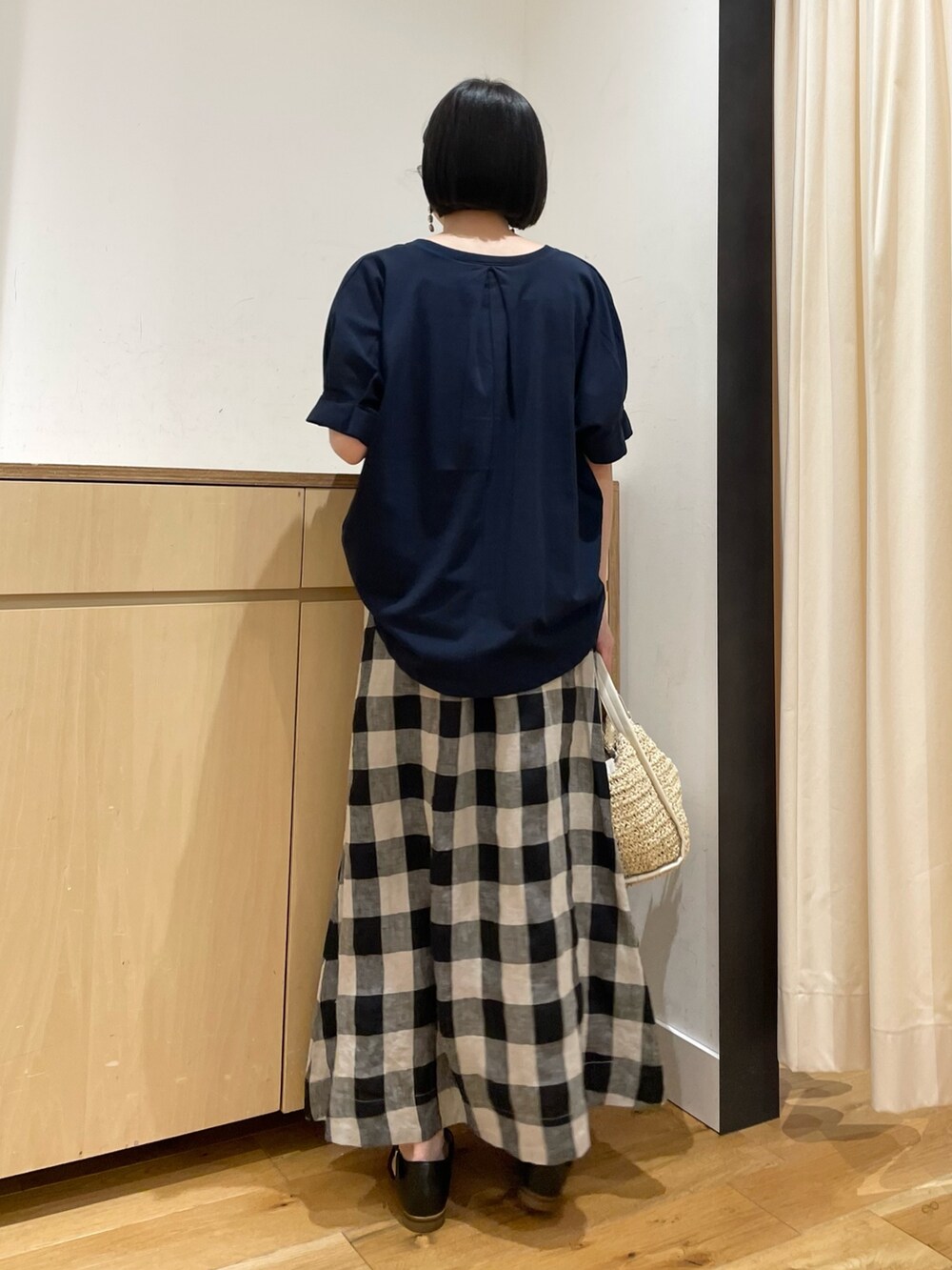 ブルー系のTシャツ/カットソー、ブラック系のスカート、ベージュ系のかごバッグを着用したレディースの夏コーディネートの7枚目の写真