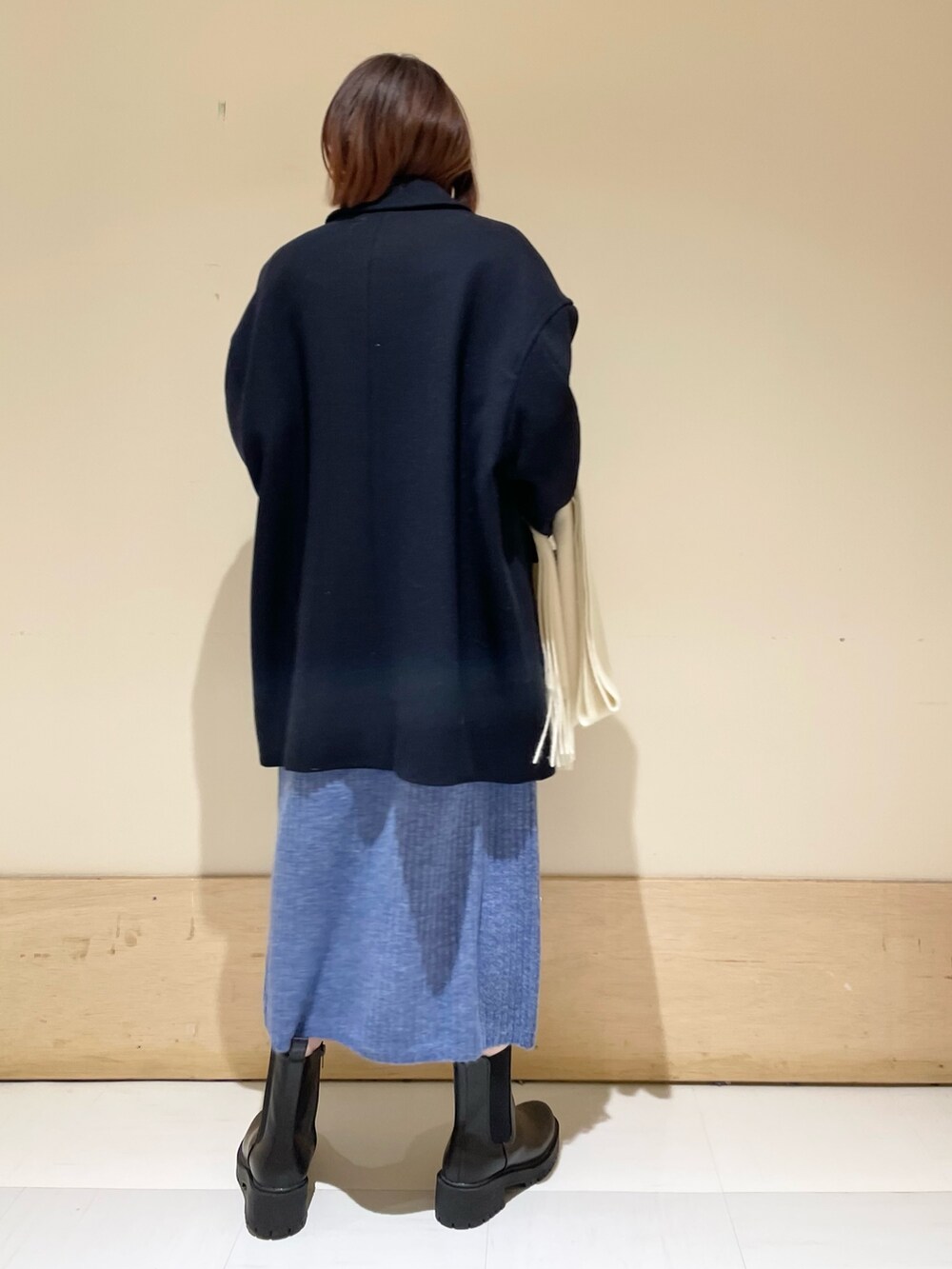 ブルー系のワンピース、ブルー系のその他アウター、ブラック系のブーツを着用したレディースの冬コーディネートの7枚目の写真