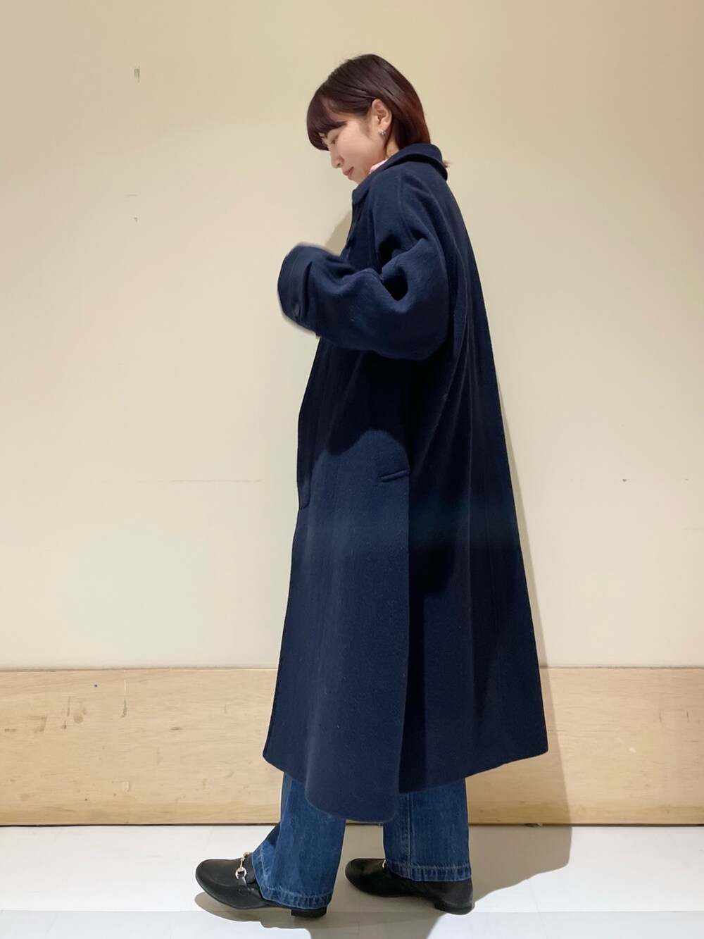 ブルー系のデニムパンツ、ピンク系のニット/セーター、ブルー系のステンカラーコートを着用したレディースの冬コーディネートの5枚目の写真