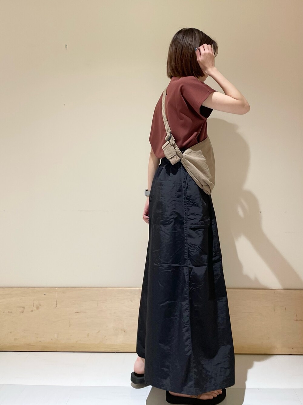 レッド系のTシャツ/カットソー、オレンジ系のサンダル、ベージュ系のショルダーバッグを着用したレディースの夏コーディネートの4枚目の写真