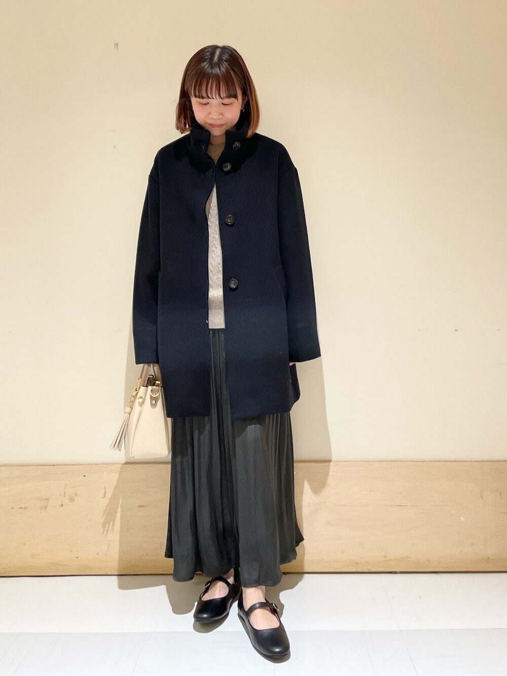 グリーン系のスカート、グレー系のニット/セーター、ブラック系のその他アウターを着用したレディースの冬コーディネートの10枚目の写真