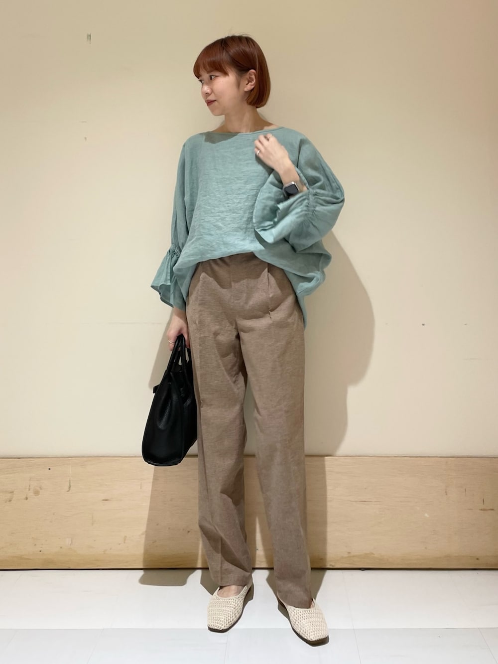 グリーン系のシャツ/ブラウス、ブラック系のトートバッグ、ホワイト系のバレエシューズを着用したレディースの春コーディネートの3枚目の写真