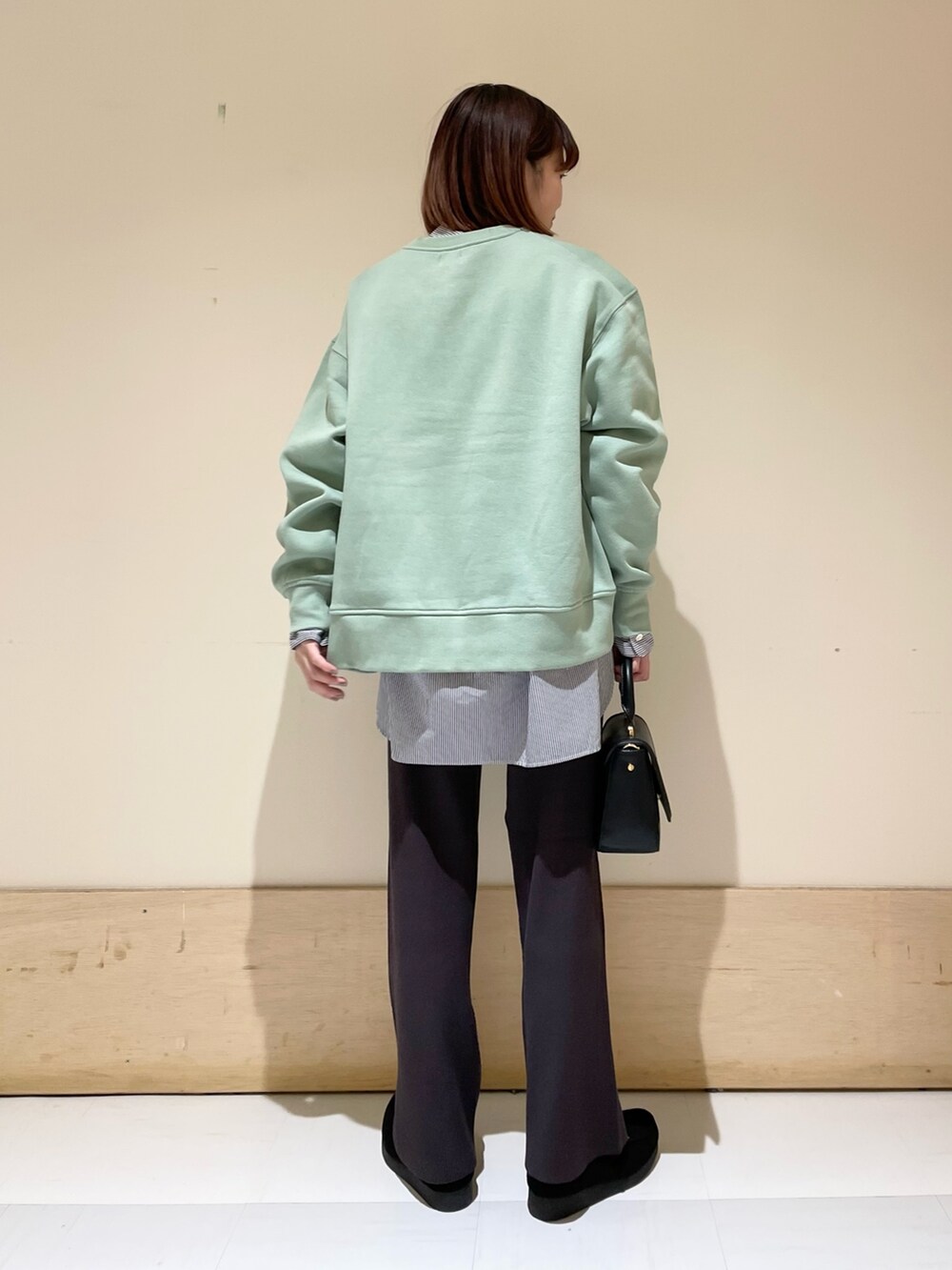 ブルー系のシャツ/ブラウス、グリーン系のスウェット、ブラック系のショルダーバッグを着用したレディースの冬コーディネートの5枚目の写真