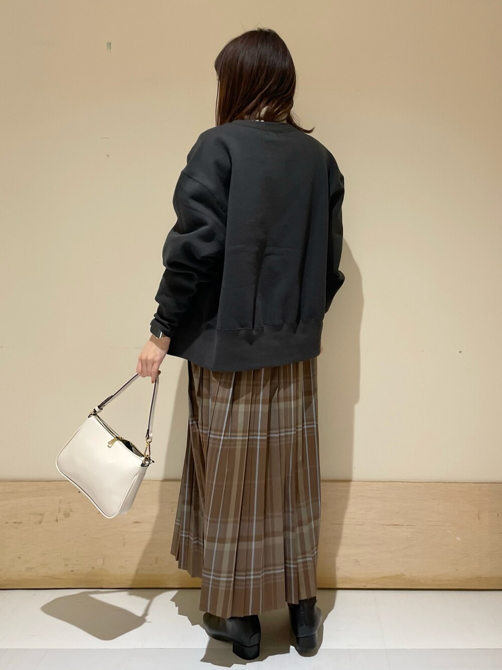 ブラウン系のスカート、グレー系のカーディガン/ボレロ、グレー系のニット/セーターを着用したレディースの冬コーディネートの4枚目の写真