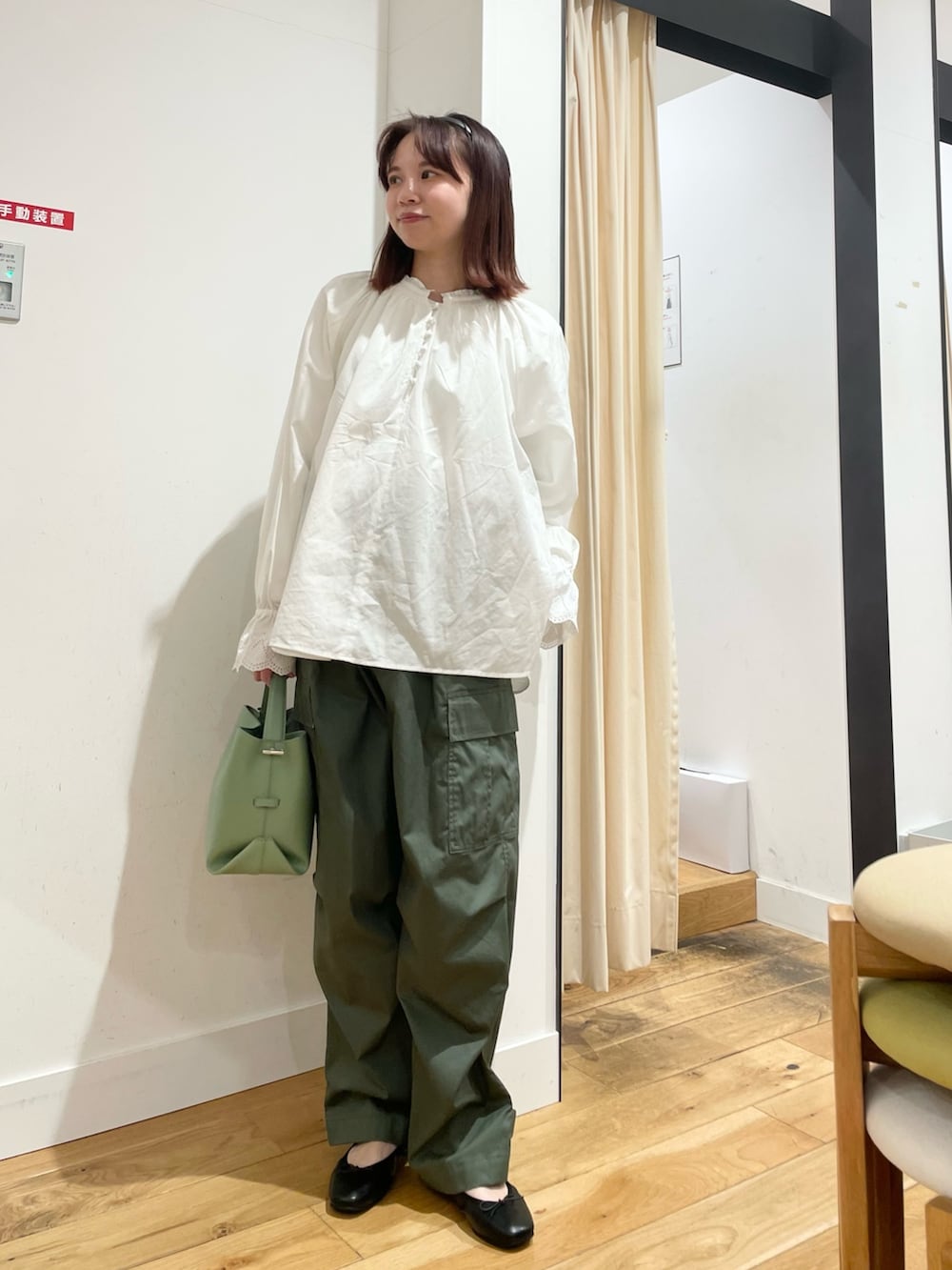 ホワイト系のシャツ/ブラウス、グリーン系のショルダーバッグ、ブラック系のバレエシューズを着用したレディースの春コーディネートの4枚目の写真