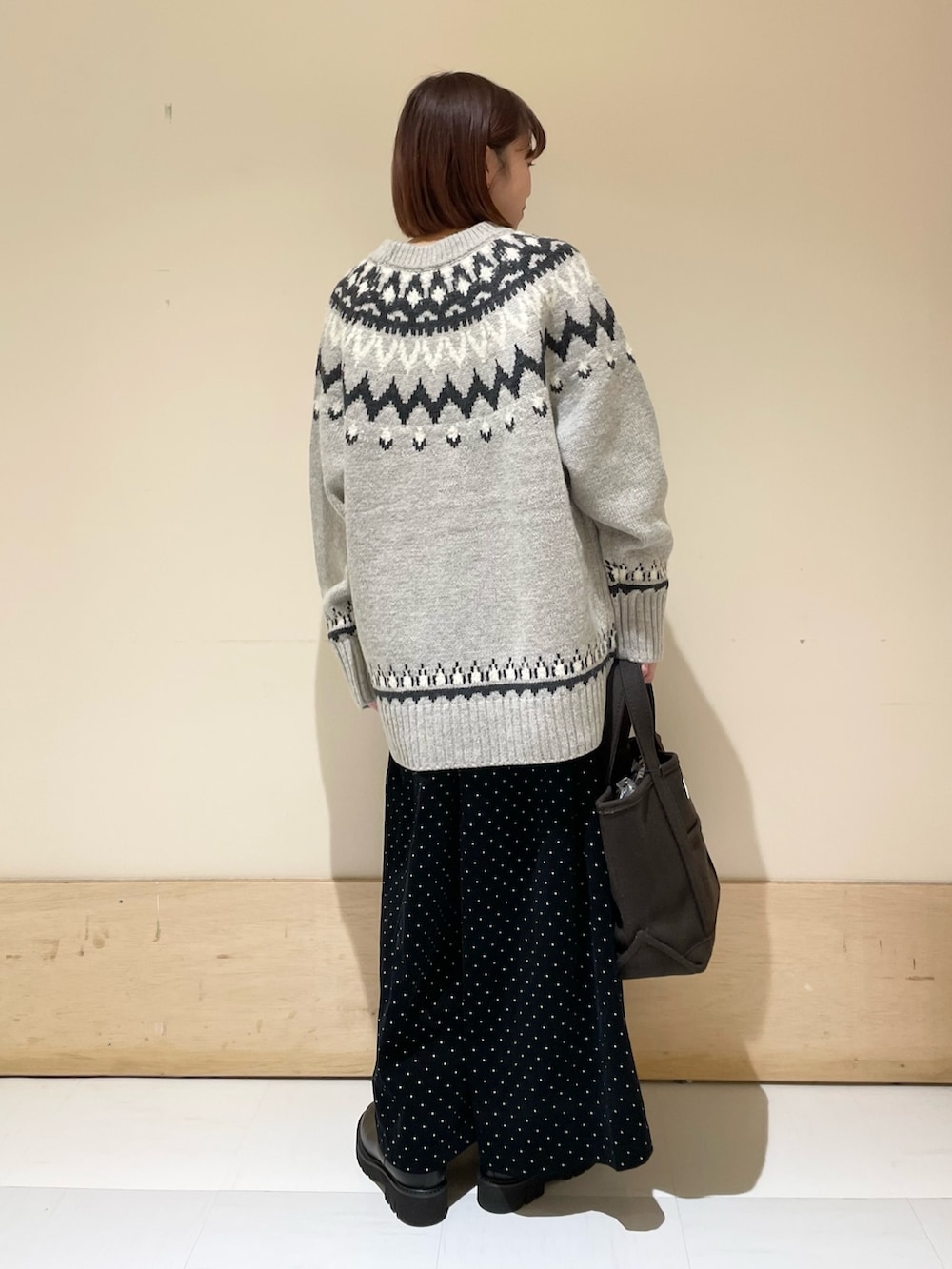 グレー系のニット/セーター、ブラック系のブーツ、ブラウン系のトートバッグを着用したレディースの秋コーディネートの8枚目の写真