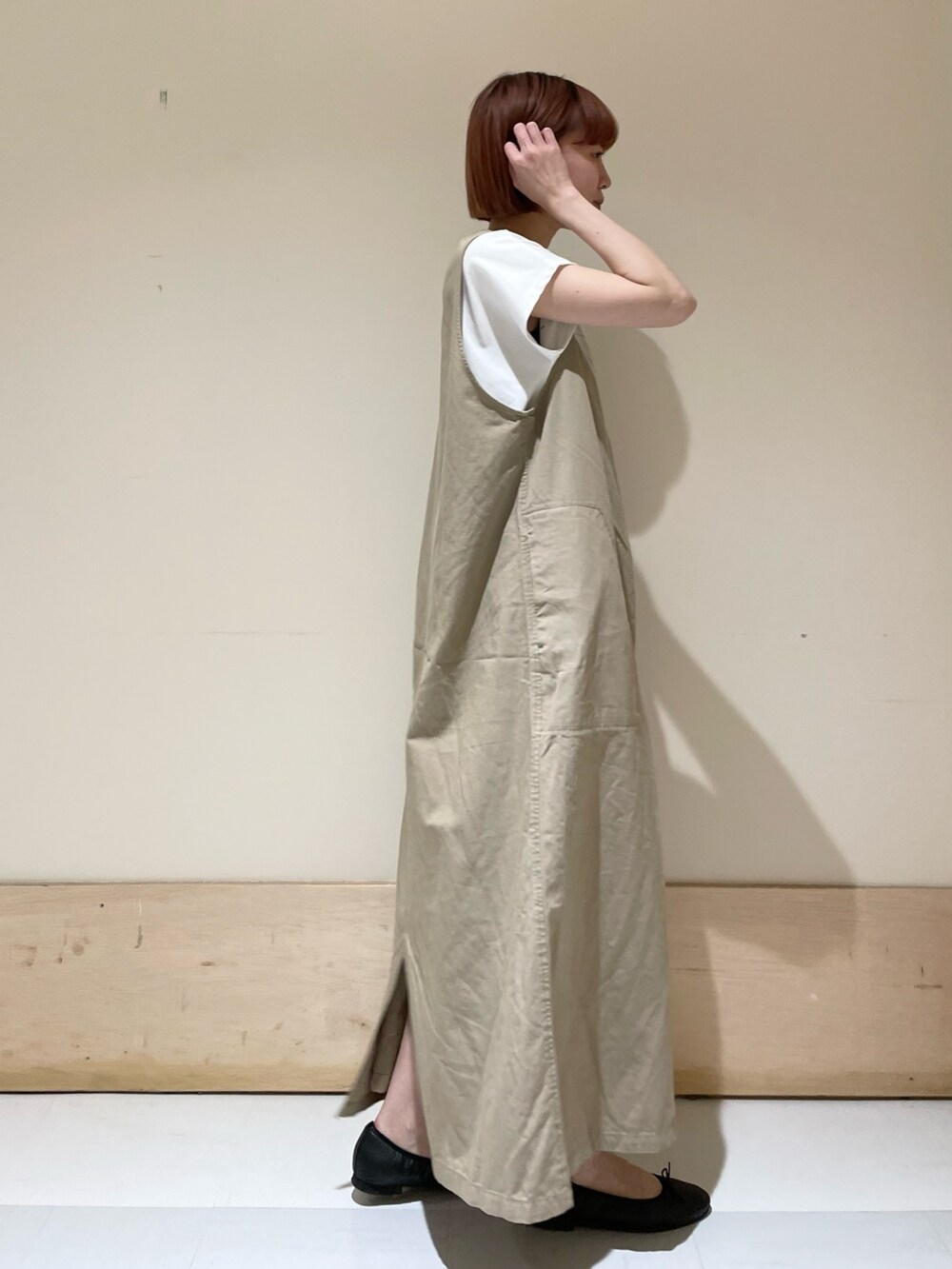 ベージュ系のワンピース、ホワイト系のTシャツ/カットソー、ブラック系のバレエシューズを着用したレディースの春コーディネートの6枚目の写真