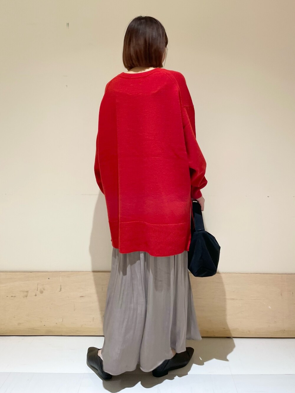 ブラック系のハンドバッグ、グレー系のスカート、ブラック系のパンプスを着用したレディースの秋コーディネートの6枚目の写真