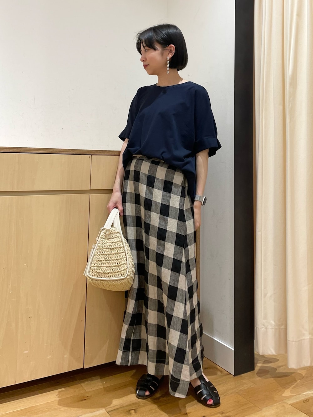 ブルー系のTシャツ/カットソー、ブラック系のスカート、ベージュ系のかごバッグを着用したレディースの夏コーディネートの4枚目の写真