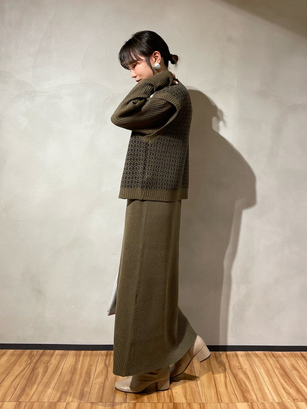 シルバー系のトートバッグ、グリーン系のワンピース、グレー系のブーツを着用したレディースの秋コーディネートの2枚目の写真