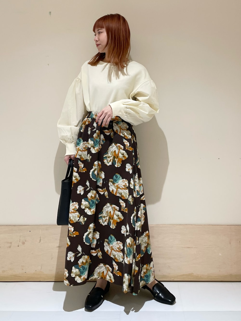 ブラウン系のスカート、ホワイト系のTシャツ/カットソーを着用したレディースの冬コーディネートの2枚目の写真