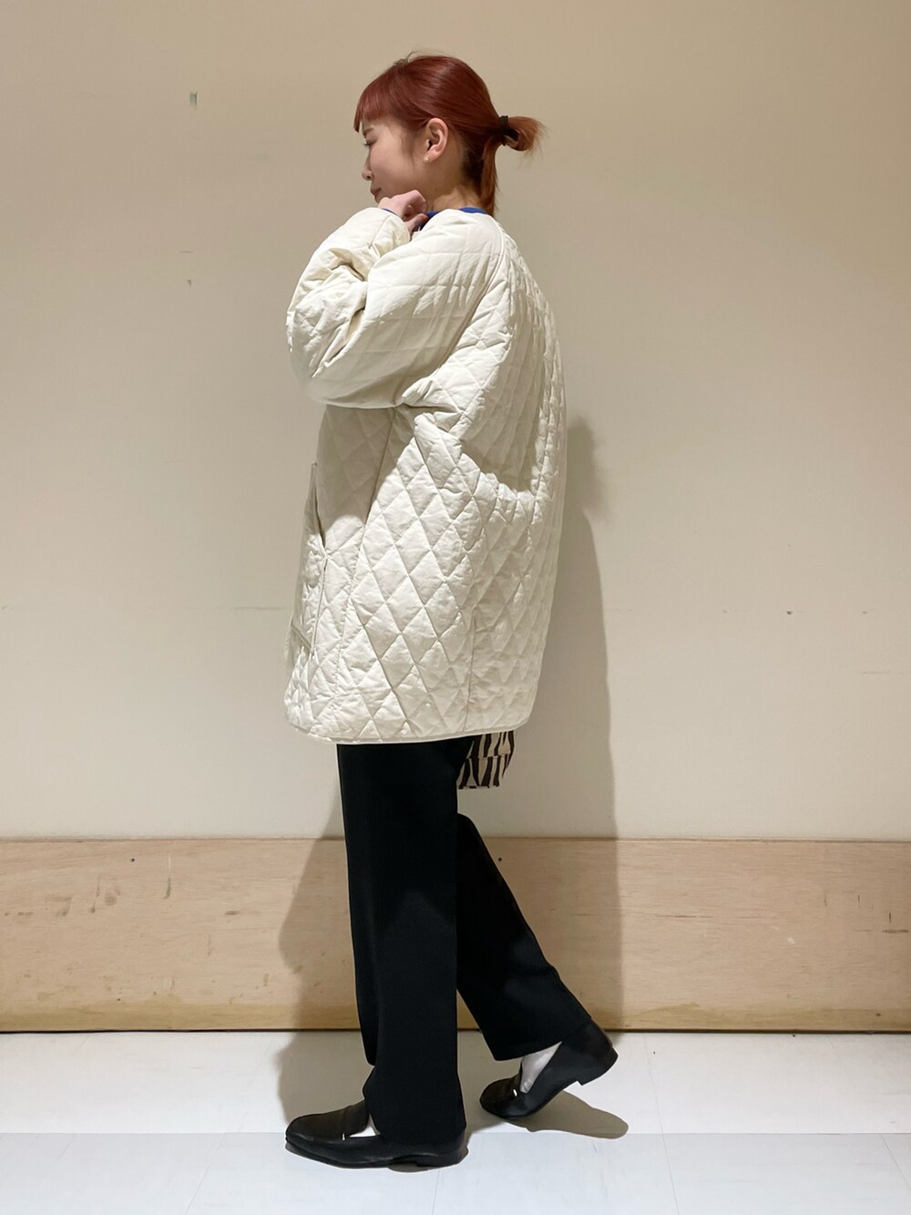 ブラック系のその他パンツ、ホワイト系のダウンジャケット/コート、ブルー系のニット/セーターを着用したレディースの冬コーディネートの3枚目の写真