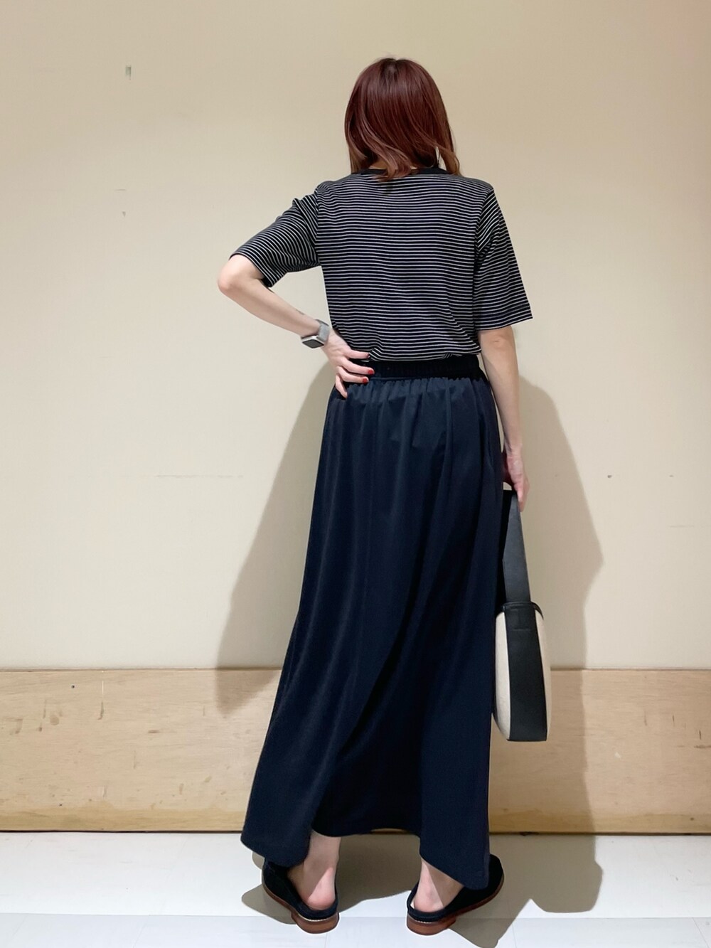 ブルー系のその他シューズ、ブルー系のスカート、ブラック系のハンドバッグを着用したレディースの春コーディネートの6枚目の写真