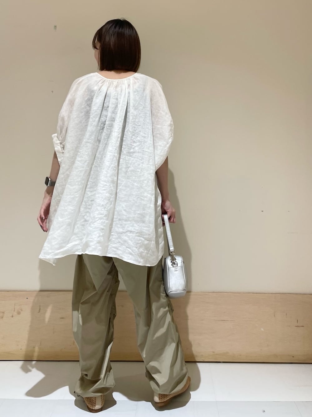 ホワイト系のシャツ/ブラウス、ベージュ系のバレエシューズ、シルバー系のショルダーバッグを着用したレディースの夏コーディネートの6枚目の写真