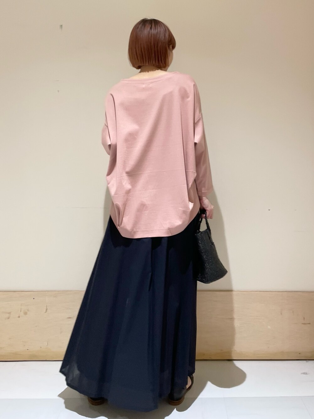 ピンク系のTシャツ/カットソー、ブルー系のスカート、ブラック系のハンドバッグを着用したレディースの春コーディネートの7枚目の写真