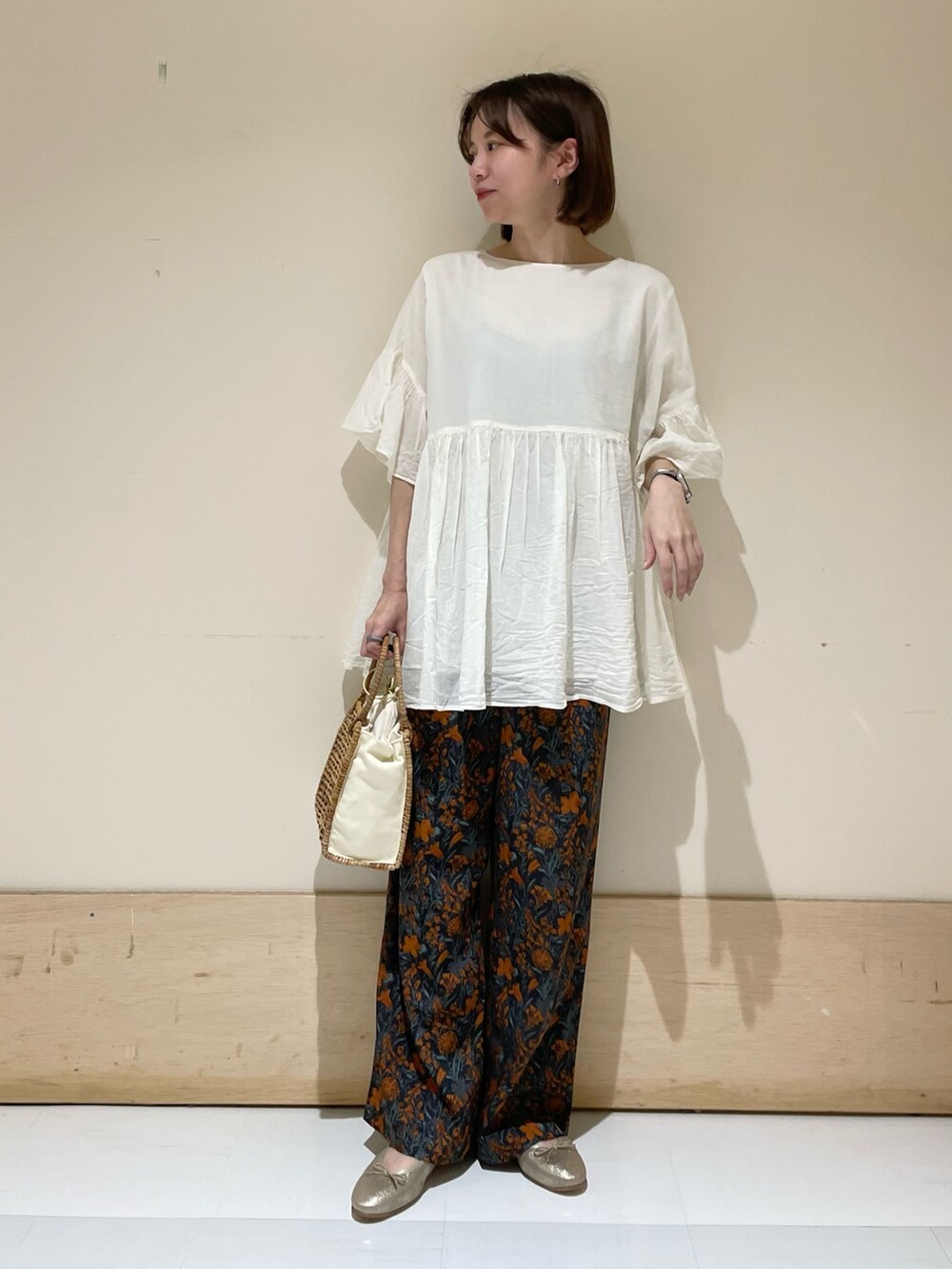 ベージュ系のハンドバッグ、ゴールド系のパンプス、オレンジ系のその他パンツを着用したレディースの夏コーディネートの2枚目の写真