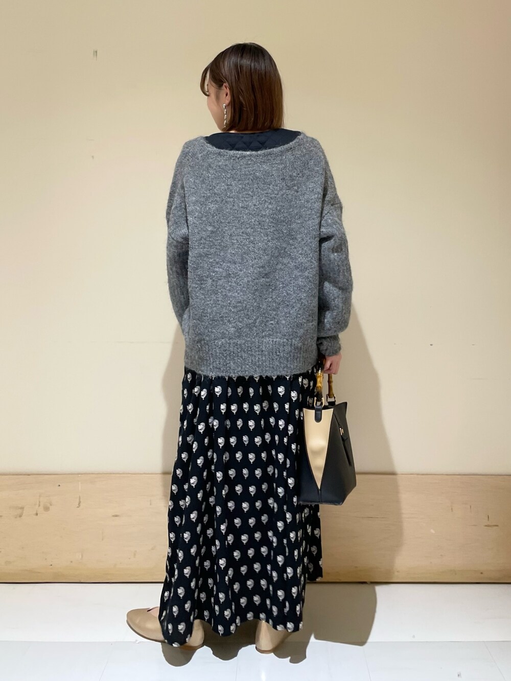 グレー系のニット/セーター、ブラック系のワンピース、ブラック系のハンドバッグを着用したレディースの秋コーディネートの5枚目の写真