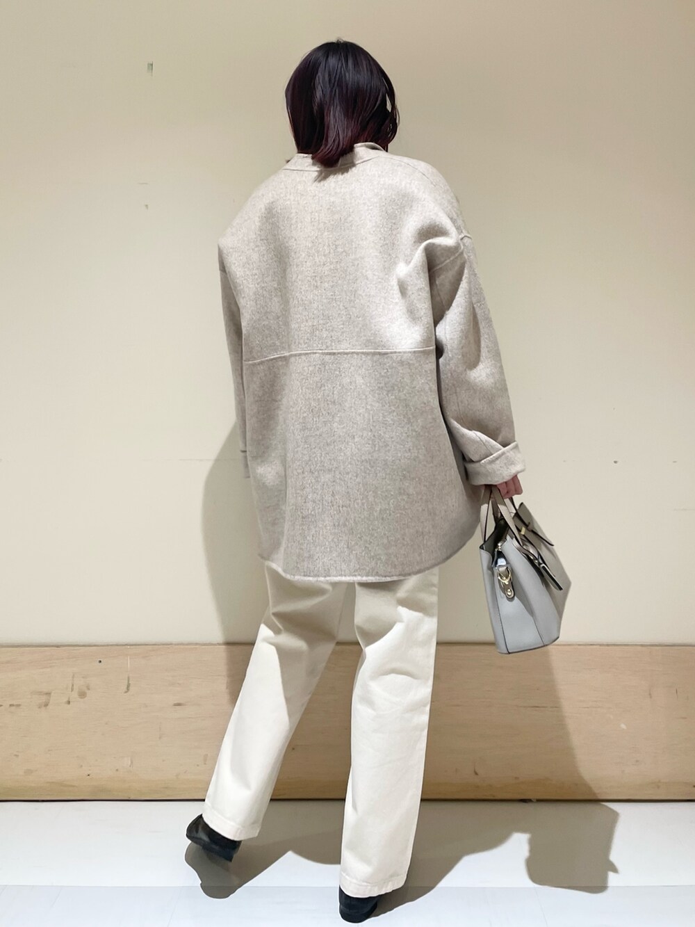 ベージュ系のデニムパンツ、ベージュ系のその他アウター、ホワイト系のTシャツ/カットソーを着用したレディースの冬コーディネートの6枚目の写真