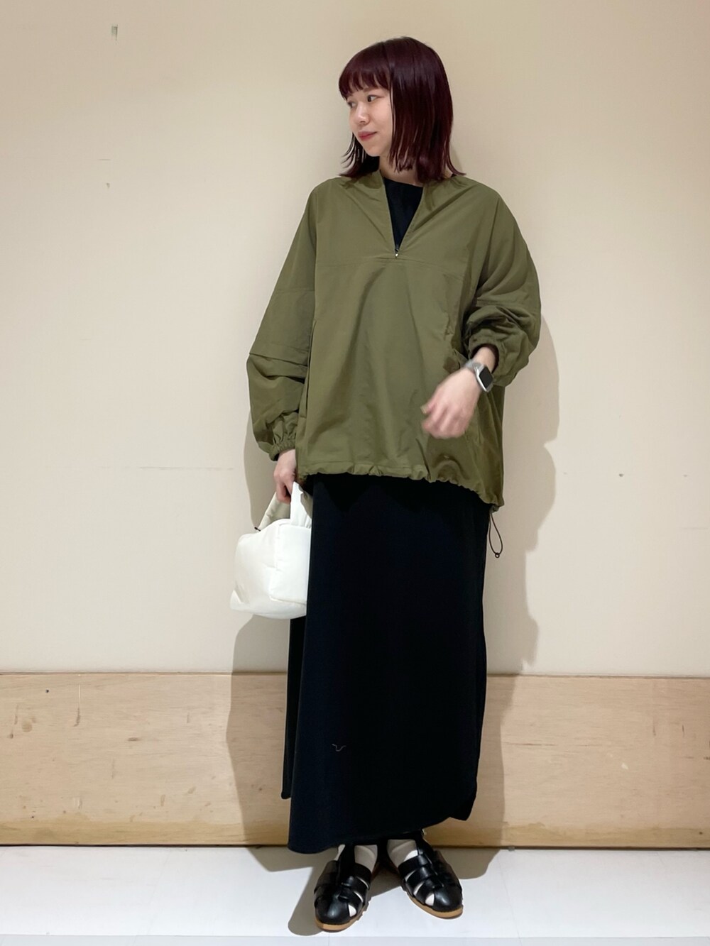 ホワイト系のハンドバッグ、ブラック系のワンピース、グリーン系のその他トップスを着用したレディースの春コーディネートの2枚目の写真