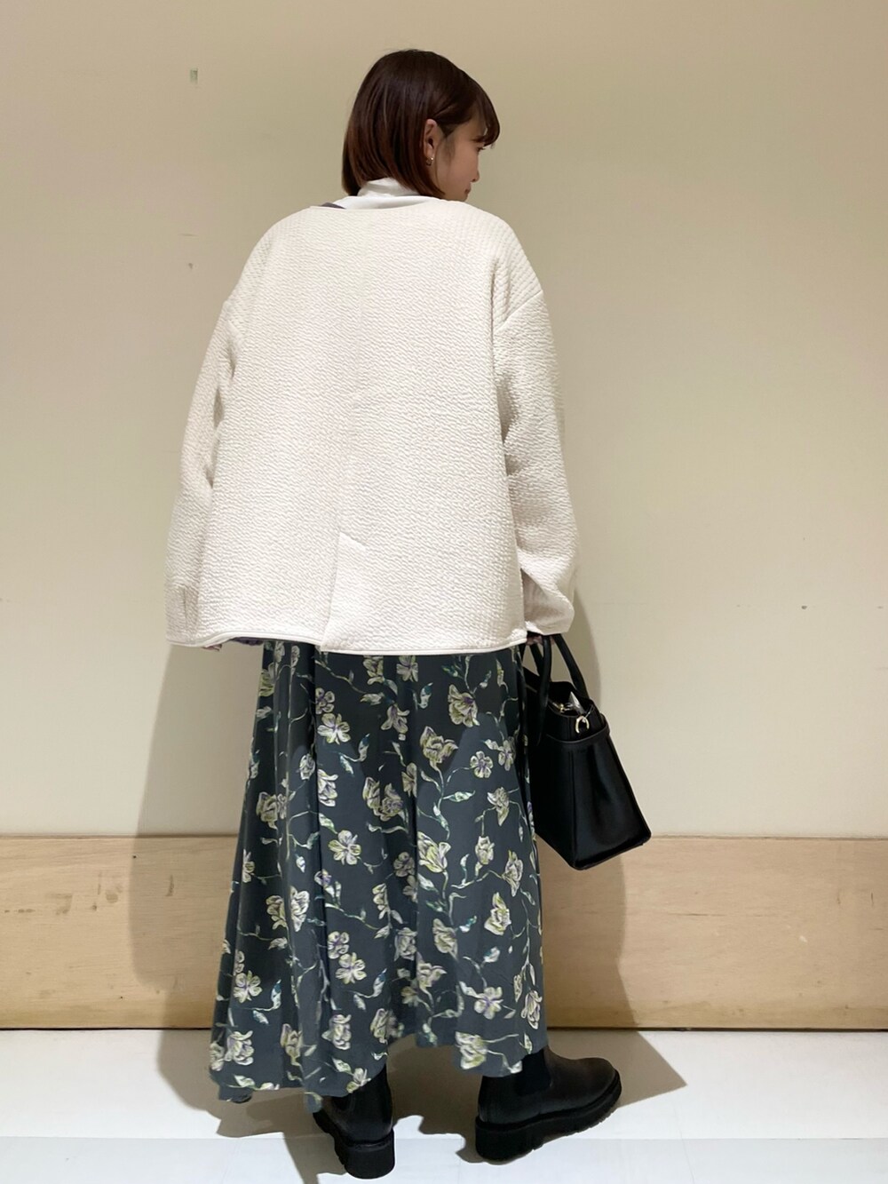 ホワイト系のTシャツ/カットソー、ホワイト系のノーカラージャケット、グレー系のスカートを着用したレディースの秋コーディネートの6枚目の写真