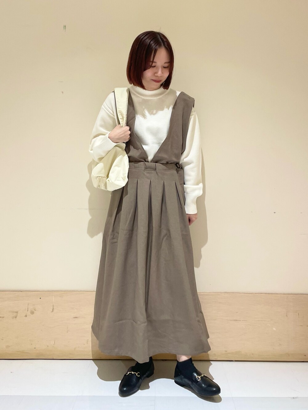 ベージュ系のニット/セーター、ブラック系のローファー、ブラウン系のサロペット/オーバーオールを着用したレディースの秋コーディネートの3枚目の写真