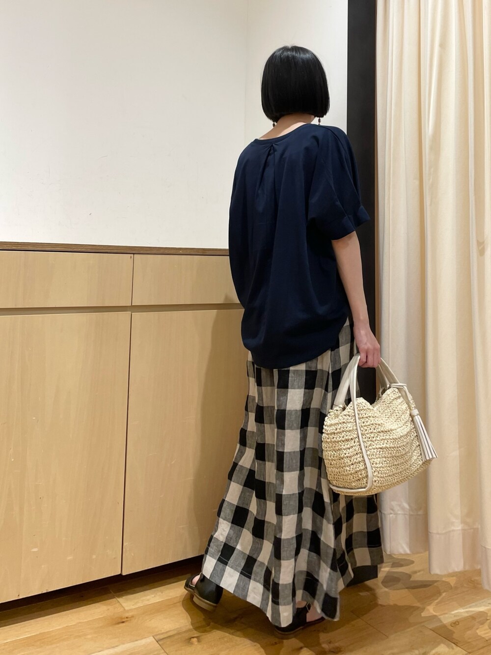 ブルー系のTシャツ/カットソー、ブラック系のスカート、ベージュ系のかごバッグを着用したレディースの夏コーディネートの3枚目の写真