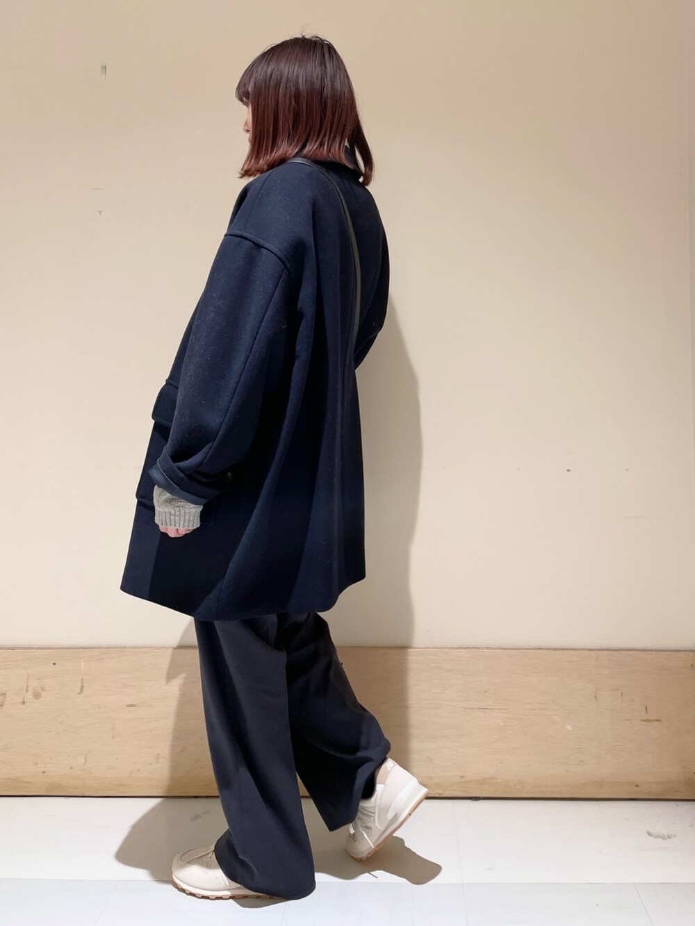 グレー系のニット/セーター、ブルー系のその他アウター、ブラック系のショルダーバッグを着用したレディースの冬コーディネートの5枚目の写真