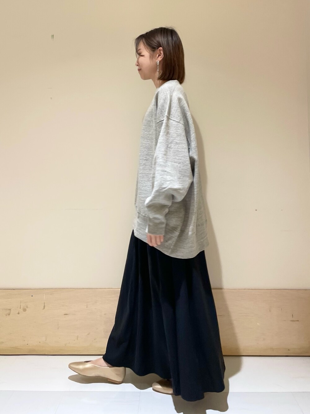 ブラック系のトートバッグ、ゴールド系のパンプス、グレー系のスウェットを着用したレディースの秋コーディネートの4枚目の写真