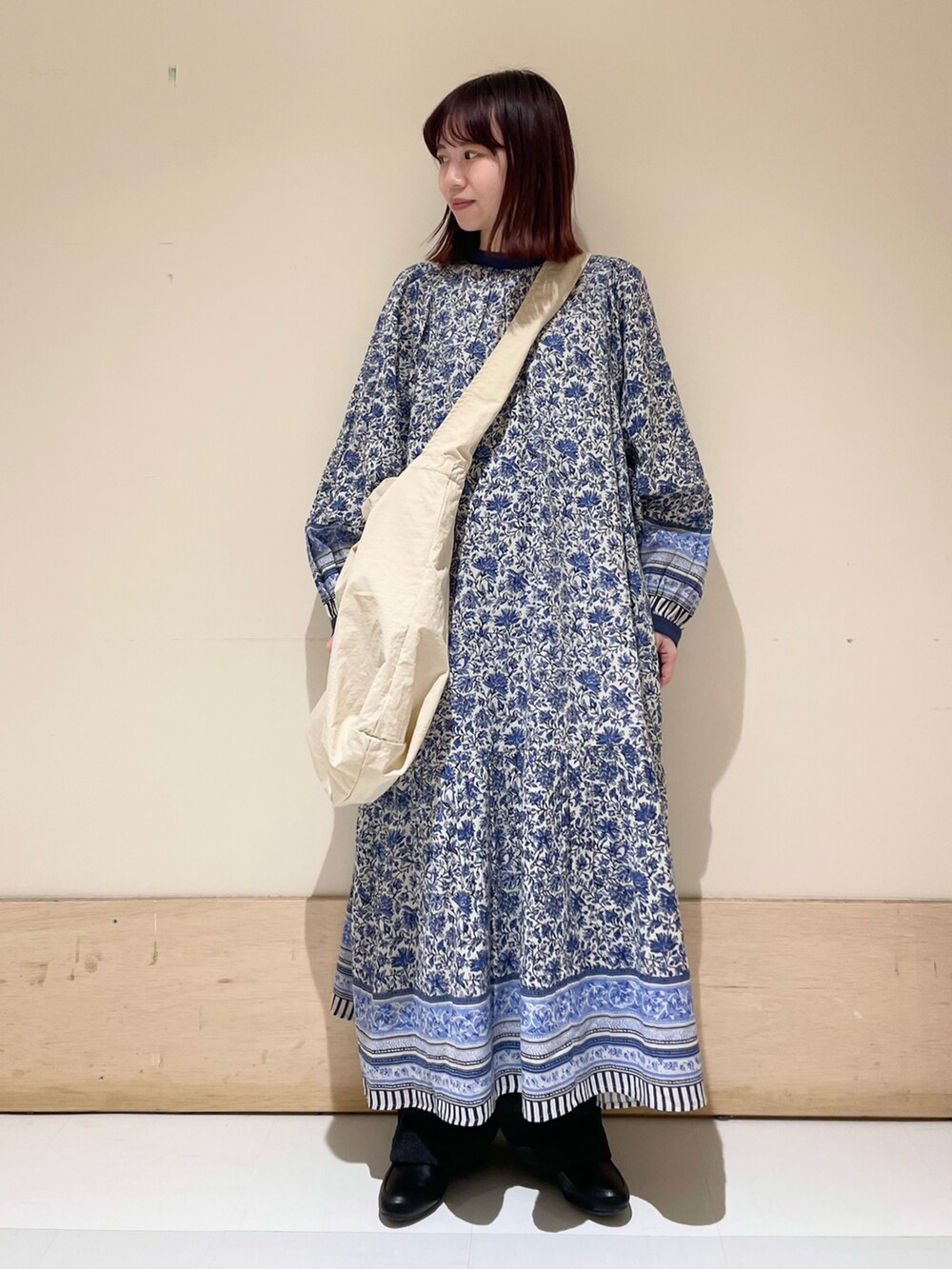 グレー系のショルダーバッグ、ブルー系のワンピース、グレー系のその他パンツを着用したレディースの冬コーディネートの2枚目の写真