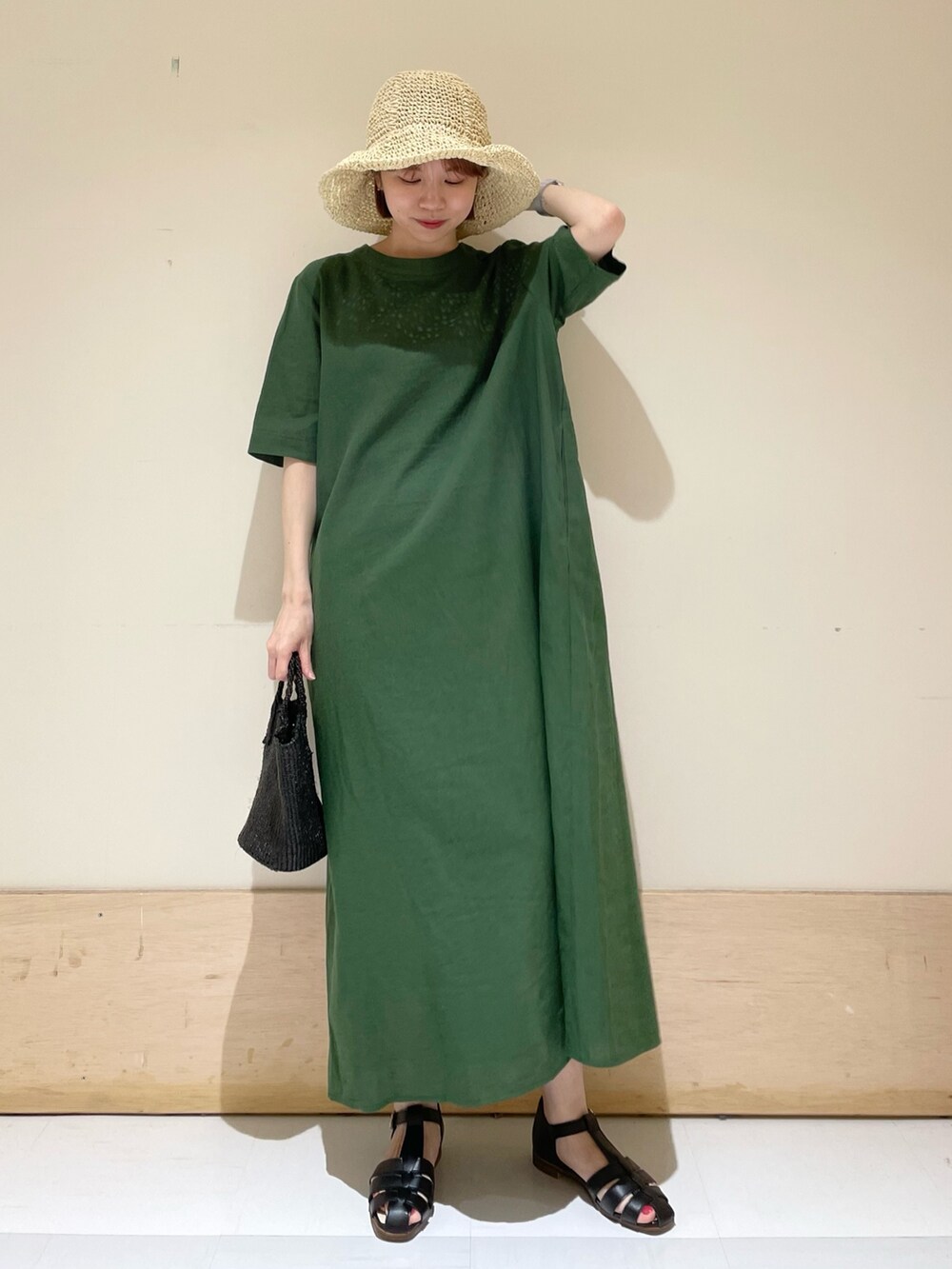 グリーン系のワンピース、ブラック系のサンダル、ブラック系のハンドバッグを着用したレディースの春コーディネートの8枚目の写真