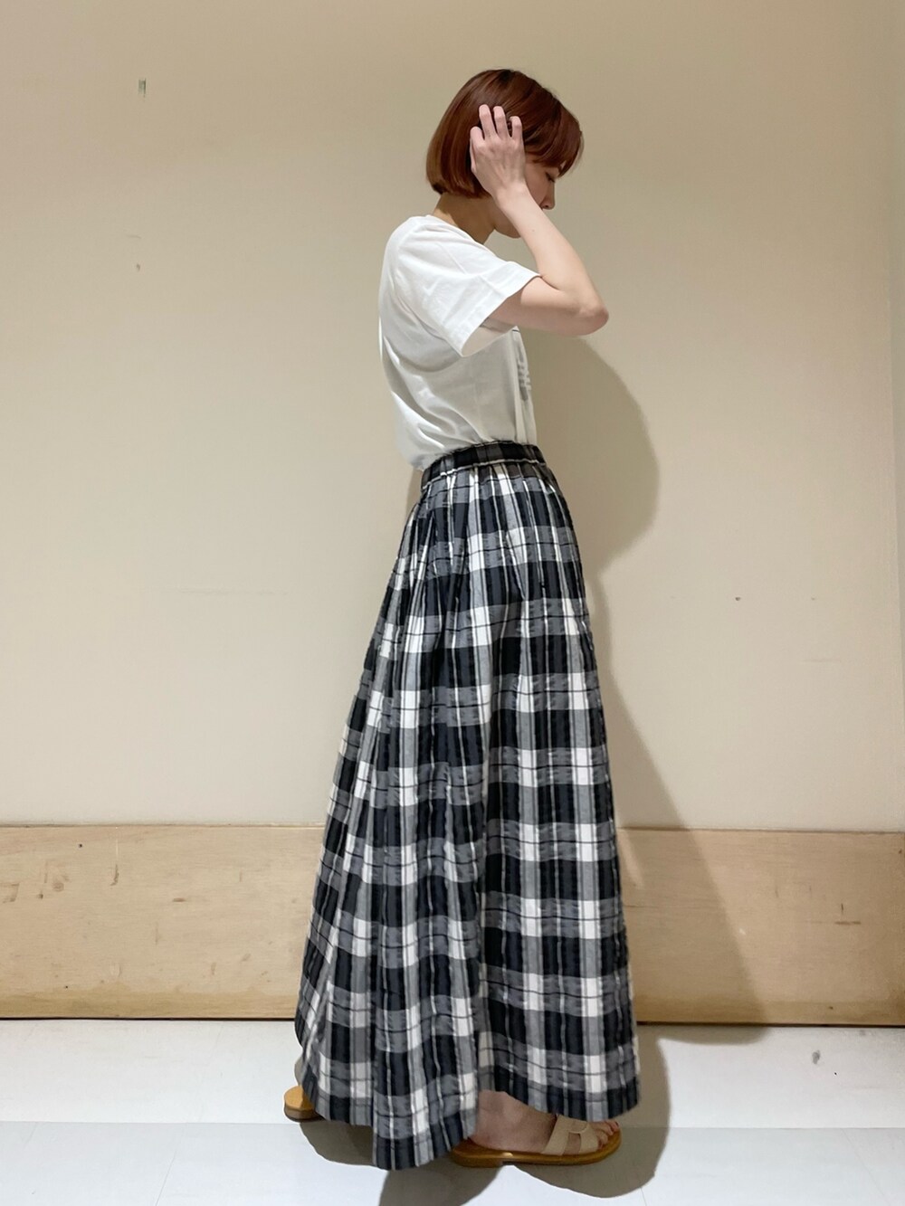 ブラック系のスカート、グレー系のTシャツ/カットソー、ブラウン系のかごバッグを着用したレディースの春コーディネートの6枚目の写真