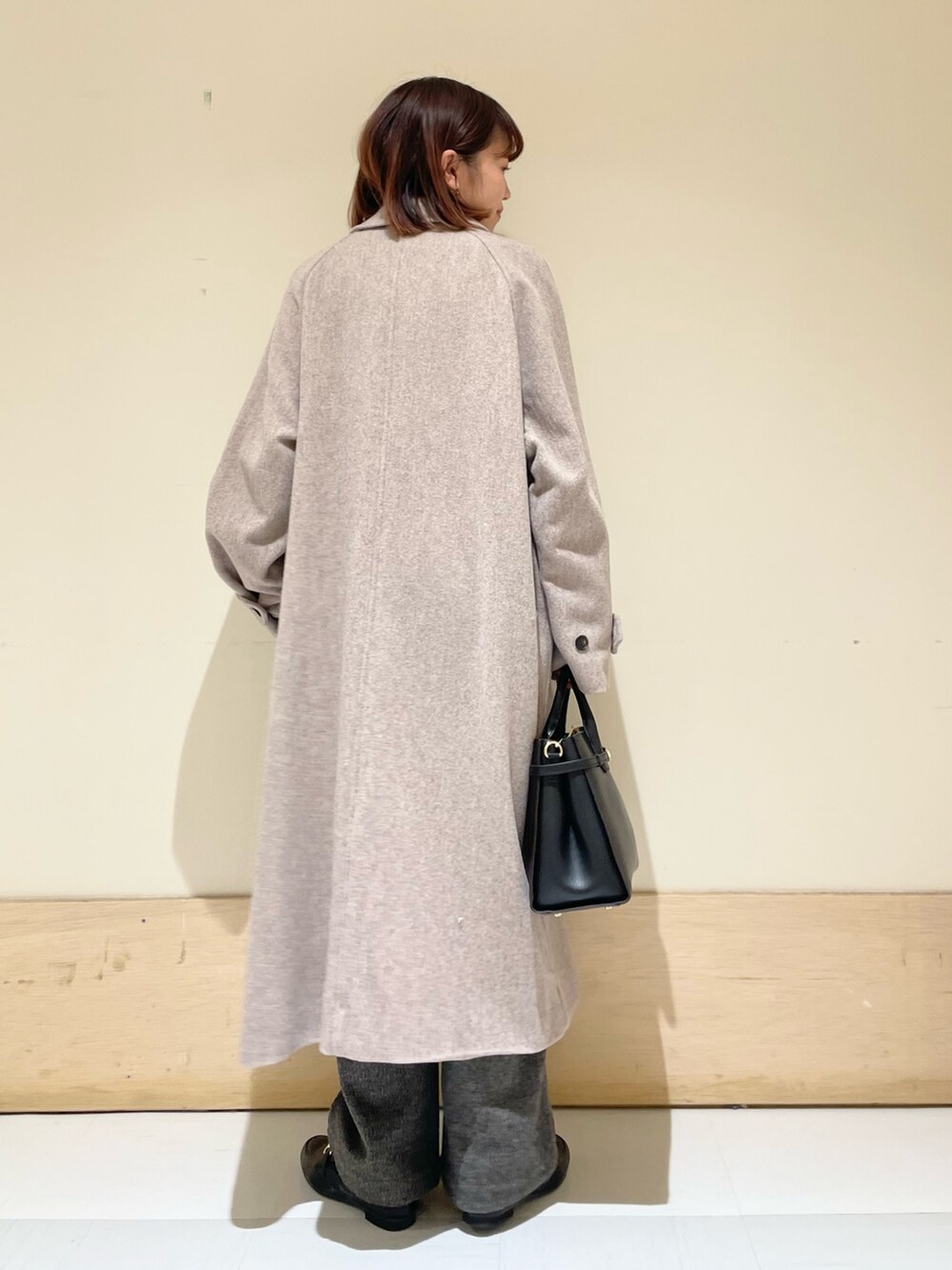 ブルー系のニット/セーター、グレー系のステンカラーコート、グレー系のその他パンツを着用したレディースの冬コーディネートの6枚目の写真