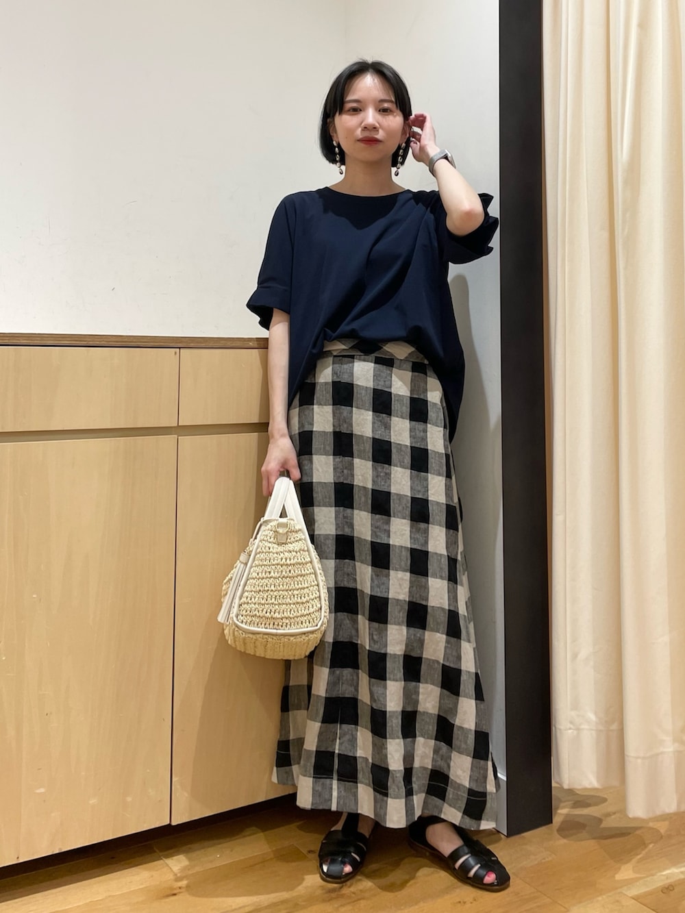 ブルー系のTシャツ/カットソー、ブラック系のスカート、ベージュ系のかごバッグを着用したレディースの夏コーディネートの2枚目の写真