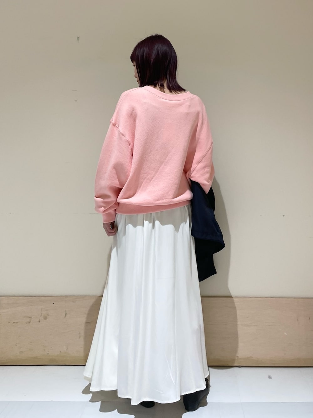 ピンク系のスウェット、ブルー系のその他アウター、ホワイト系のスカートを着用したレディースの春コーディネートの4枚目の写真