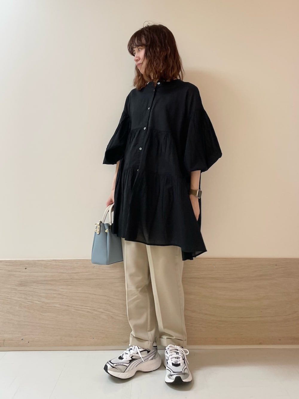 ブラック系のチュニック、ベージュ系のその他パンツを着用したレディースの春コーディネートの4枚目の写真