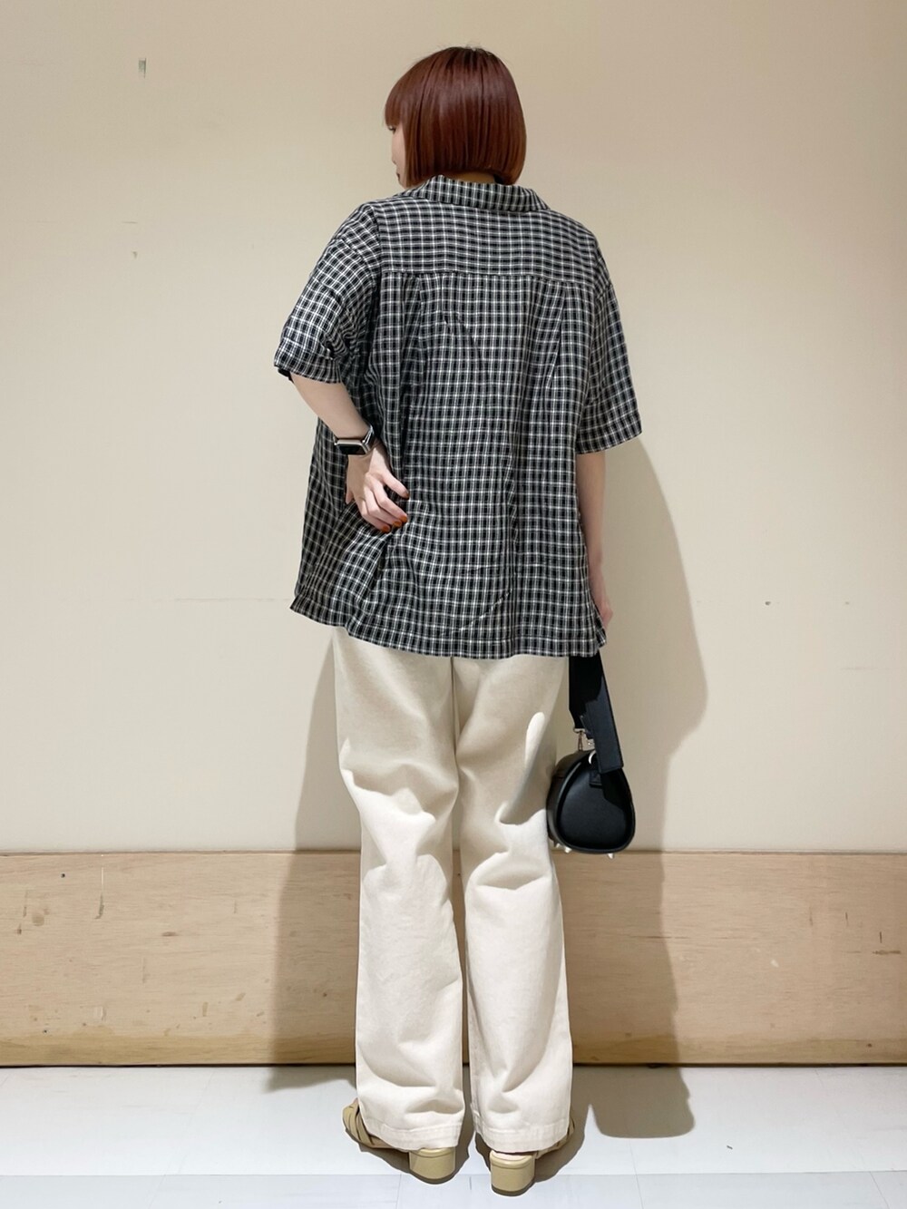 ホワイト系のTシャツ/カットソー、ベージュ系のデニムパンツ、ブラック系のショルダーバッグを着用したレディースの春コーディネートの5枚目の写真