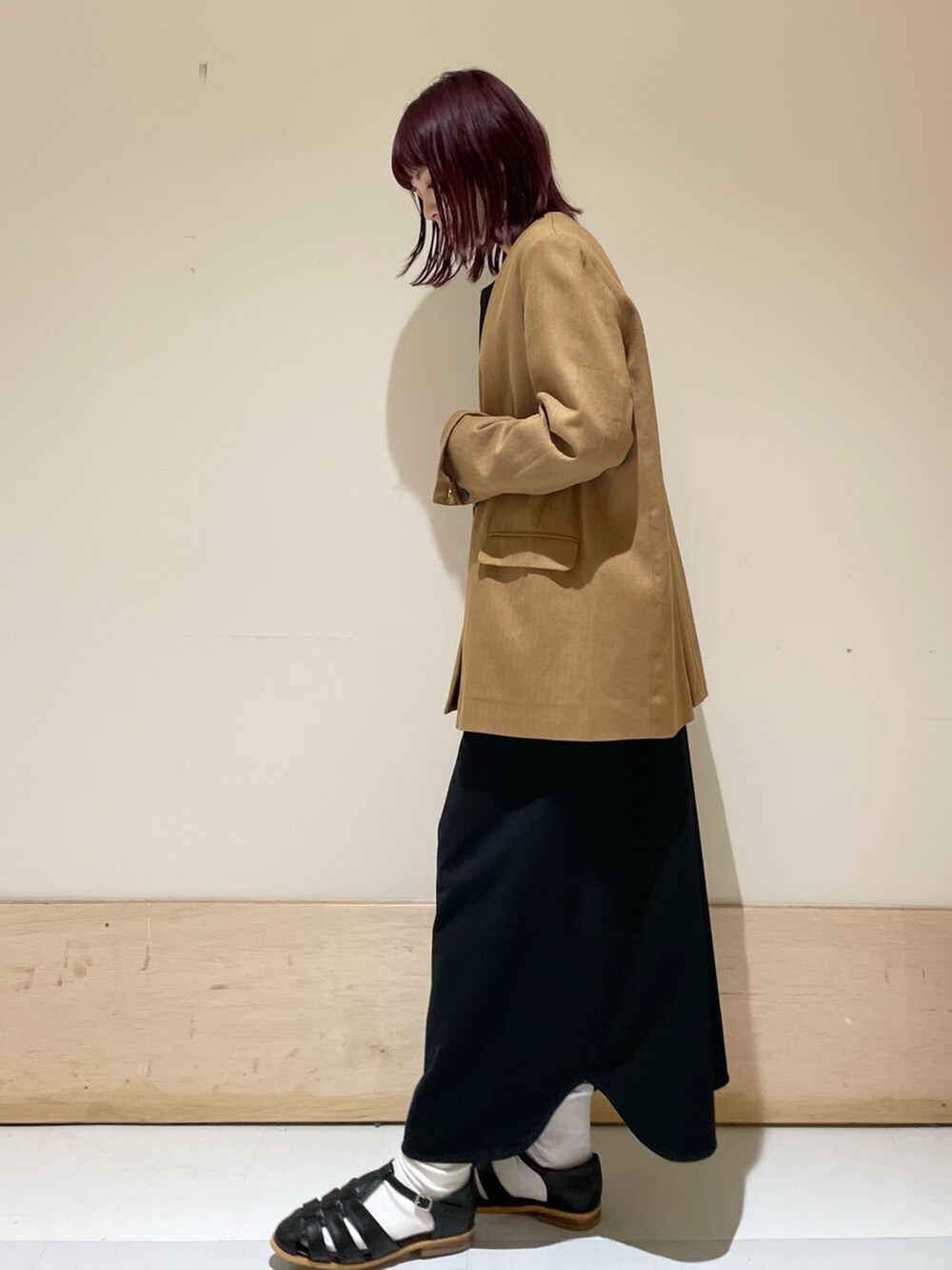 ブラック系のワンピース、ベージュ系のノーカラージャケット、ブラック系のサンダルを着用したレディースの春コーディネートの5枚目の写真