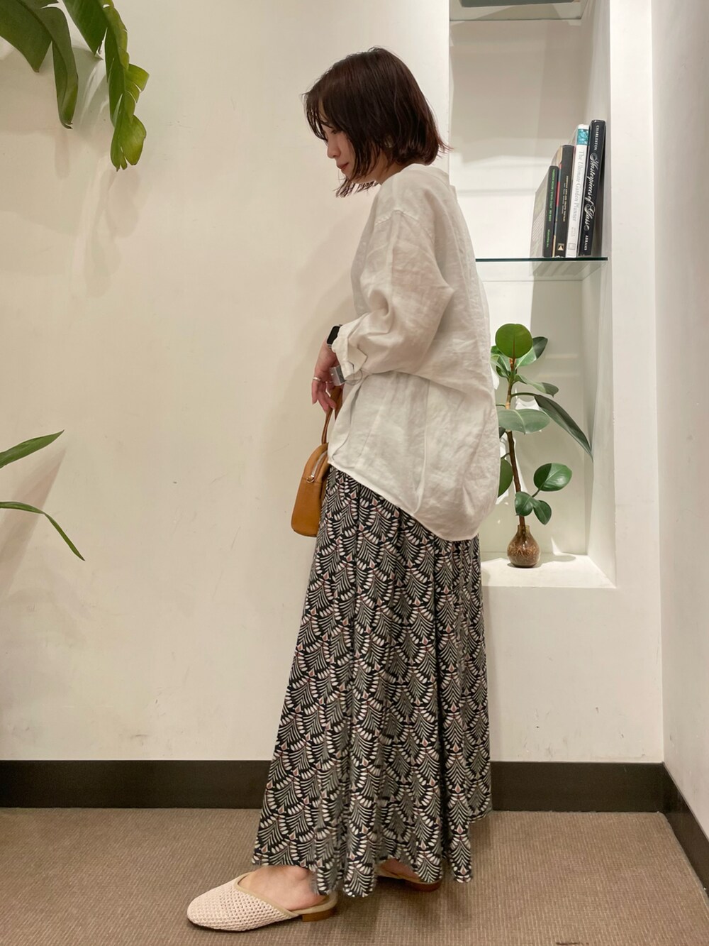 ホワイト系のサンダル、ホワイト系のシャツ/ブラウス、グリーン系のスカートを着用したレディースの春コーディネートの3枚目の写真