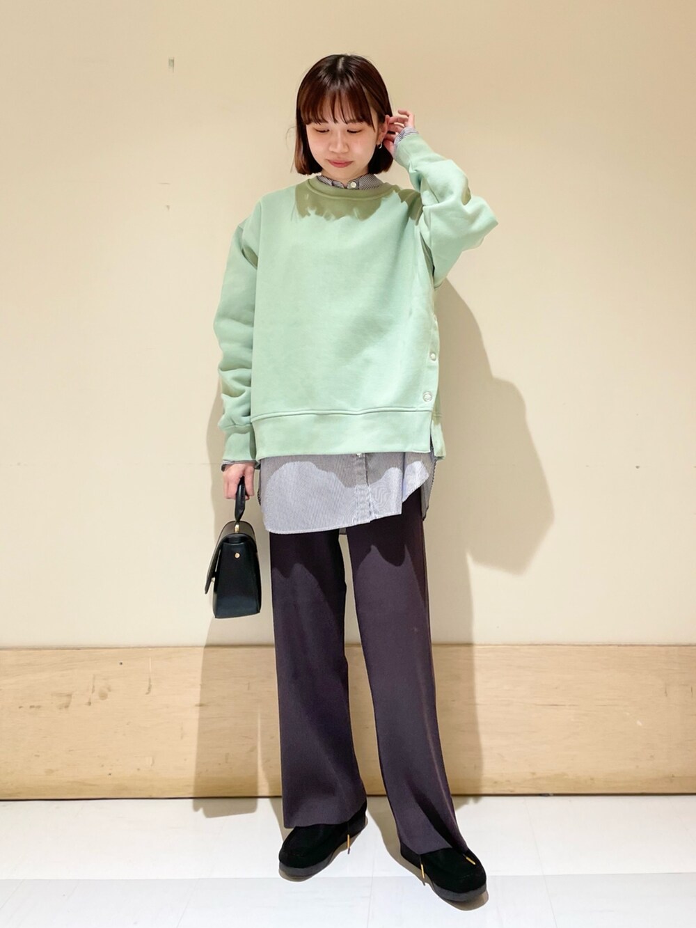 ブルー系のシャツ/ブラウス、グリーン系のスウェット、ブラック系のショルダーバッグを着用したレディースの冬コーディネートの2枚目の写真