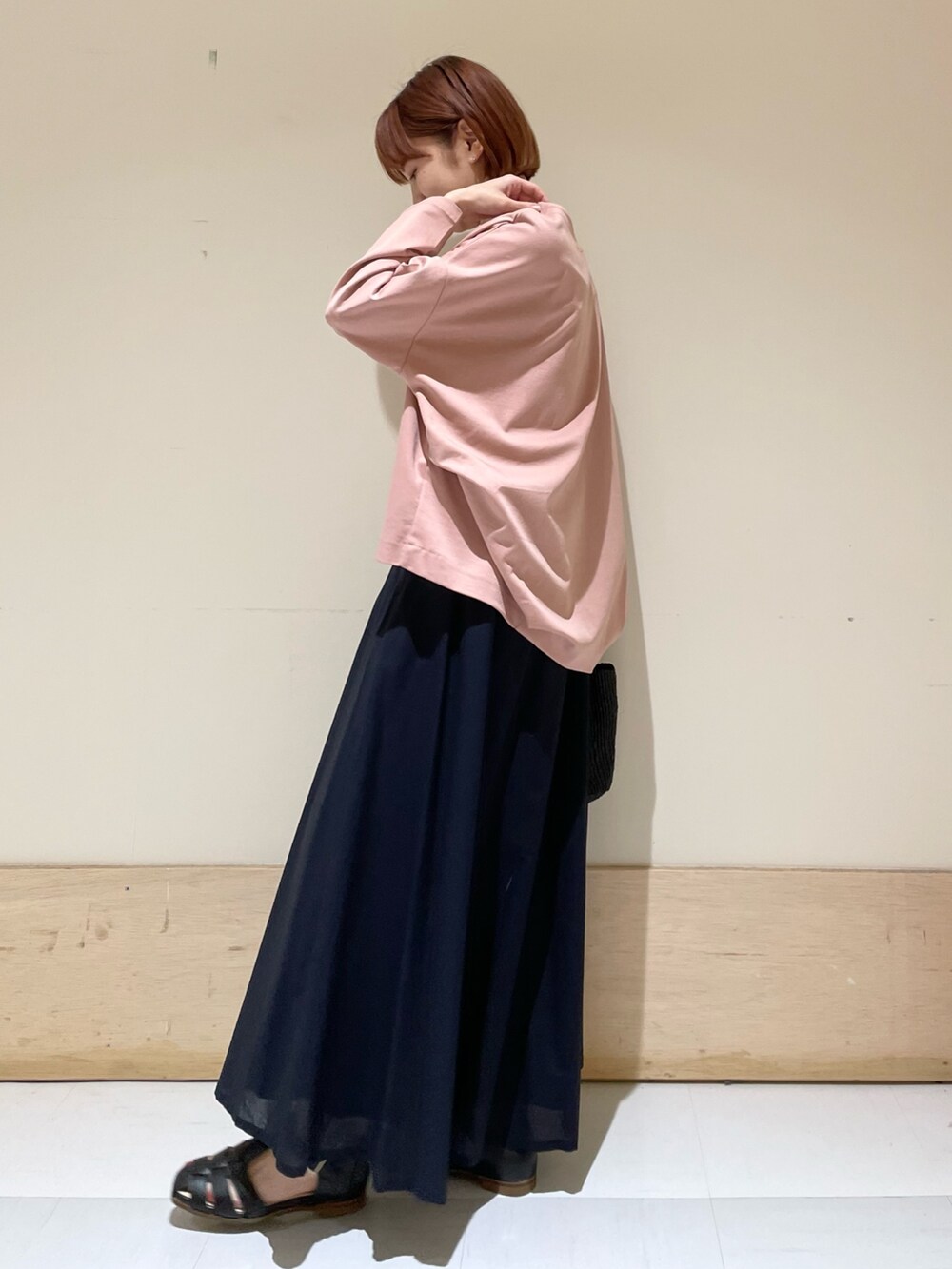 ピンク系のTシャツ/カットソー、ブルー系のスカート、ブラック系のハンドバッグを着用したレディースの春コーディネートの5枚目の写真