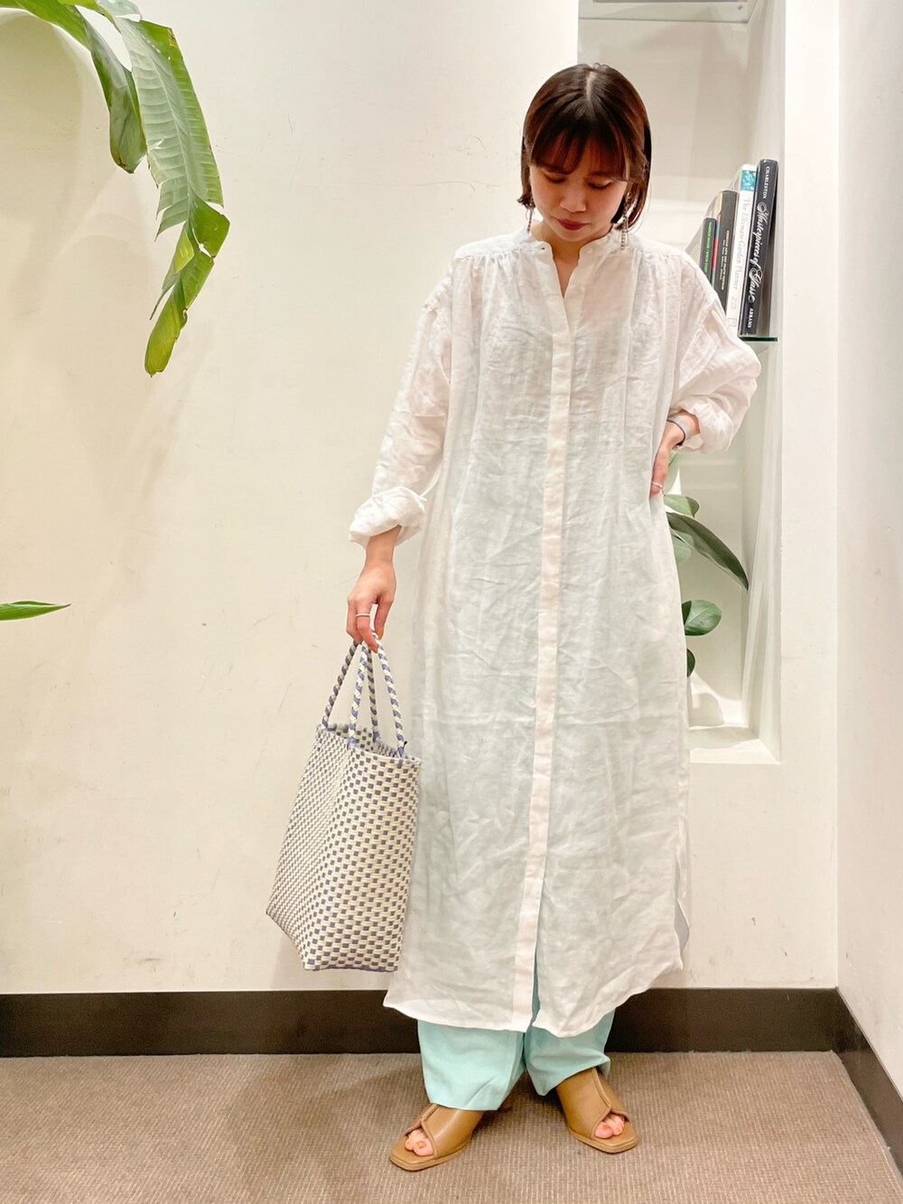 パープル系のトートバッグ、ホワイト系のワンピース、ベージュ系のサンダルを着用したレディースの夏コーディネートの2枚目の写真