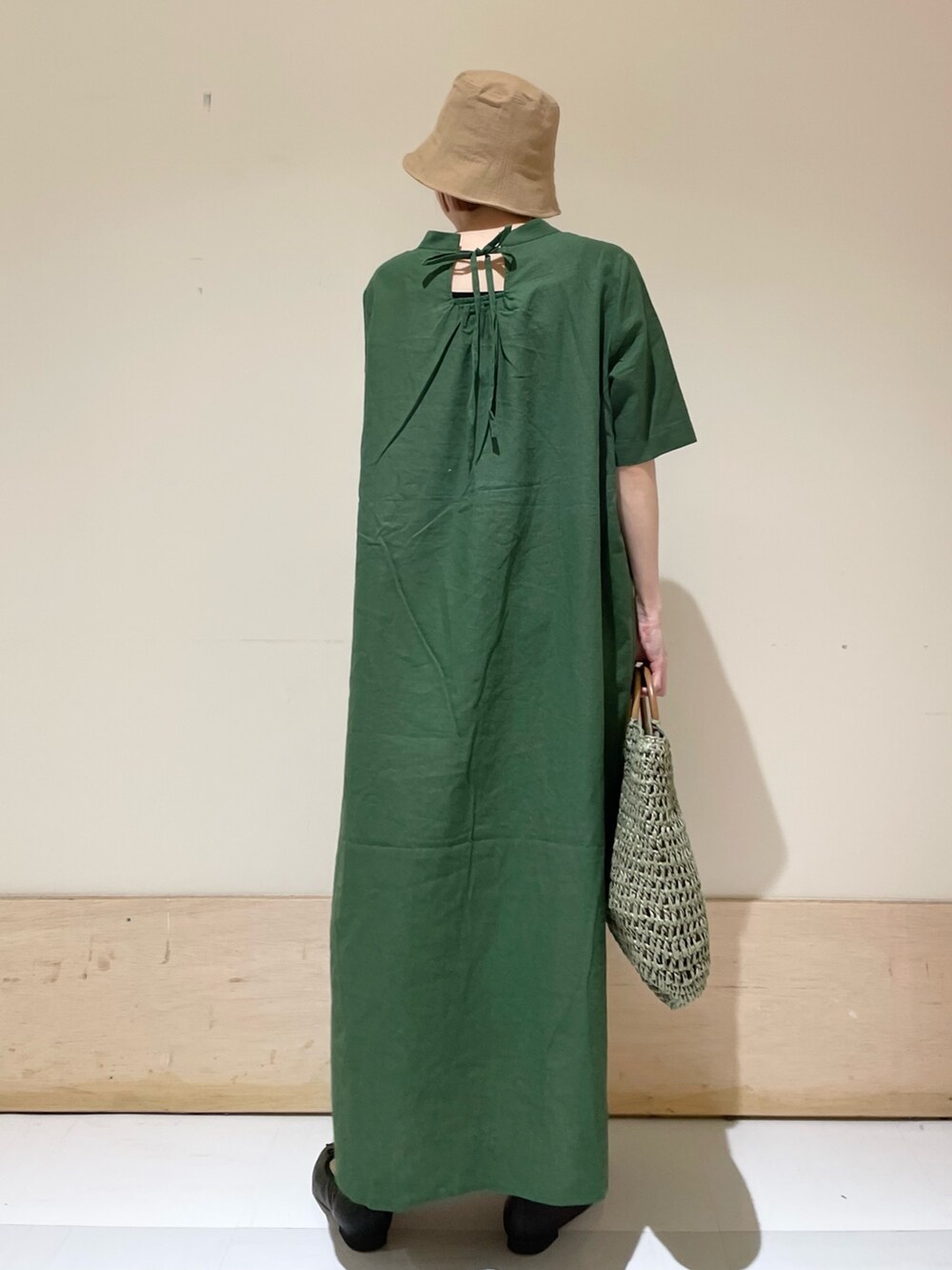 グリーン系のワンピース、ブラック系のバレエシューズ、グリーン系のかごバッグを着用したレディースの春コーディネートの7枚目の写真