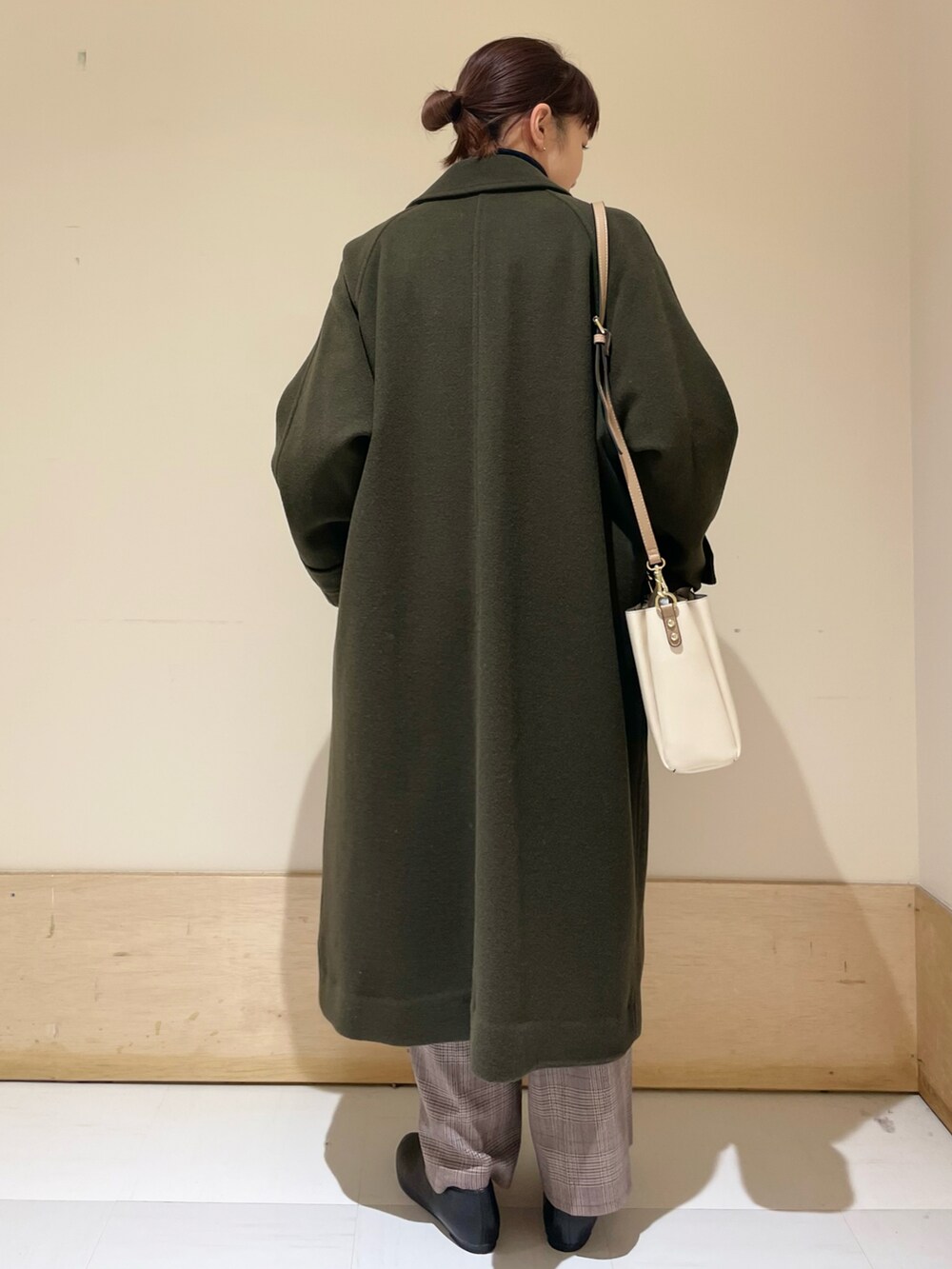 ブルー系のニット/セーター、グリーン系のステンカラーコート、ブラウン系のその他パンツを着用したレディースの冬コーディネートの3枚目の写真