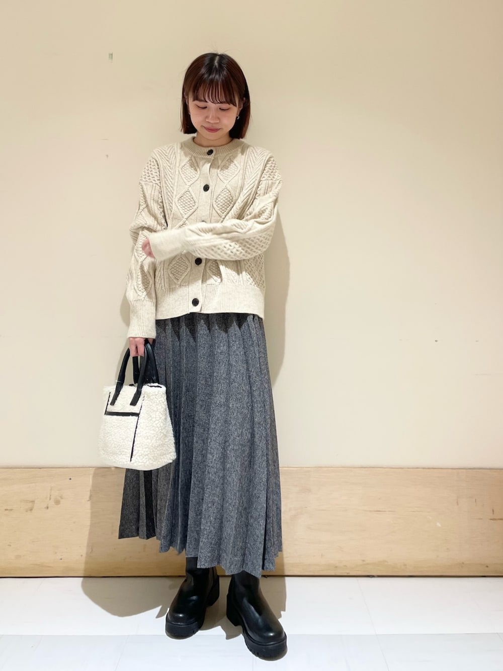 ホワイト系のカーディガン/ボレロ、ブルー系のスカート、ホワイト系のショルダーバッグを着用したレディースの冬コーディネートの2枚目の写真