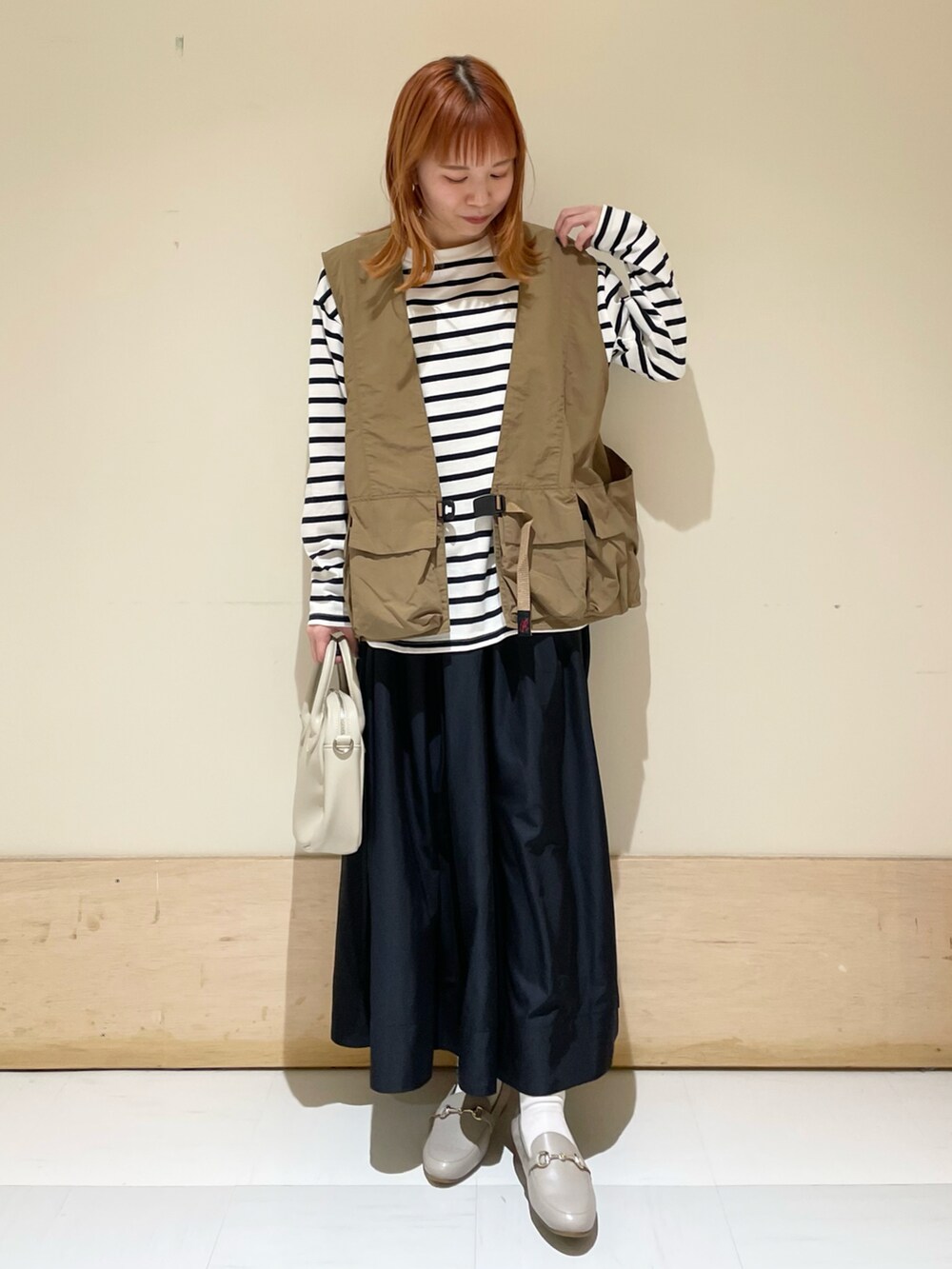 ブルー系のスカート、ブルー系のTシャツ/カットソー、ベージュ系のショルダーバッグを着用したレディースの春コーディネートの3枚目の写真