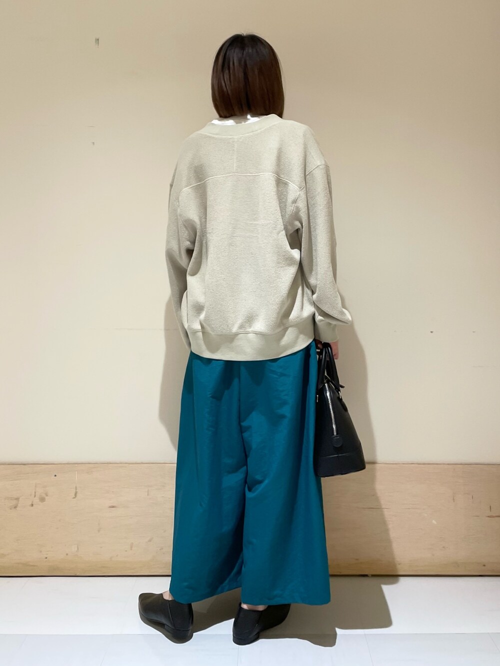 ベージュ系のカーディガン/ボレロ、ホワイト系のTシャツ/カットソー、ブラック系のショルダーバッグを着用したレディースの秋コーディネートの6枚目の写真